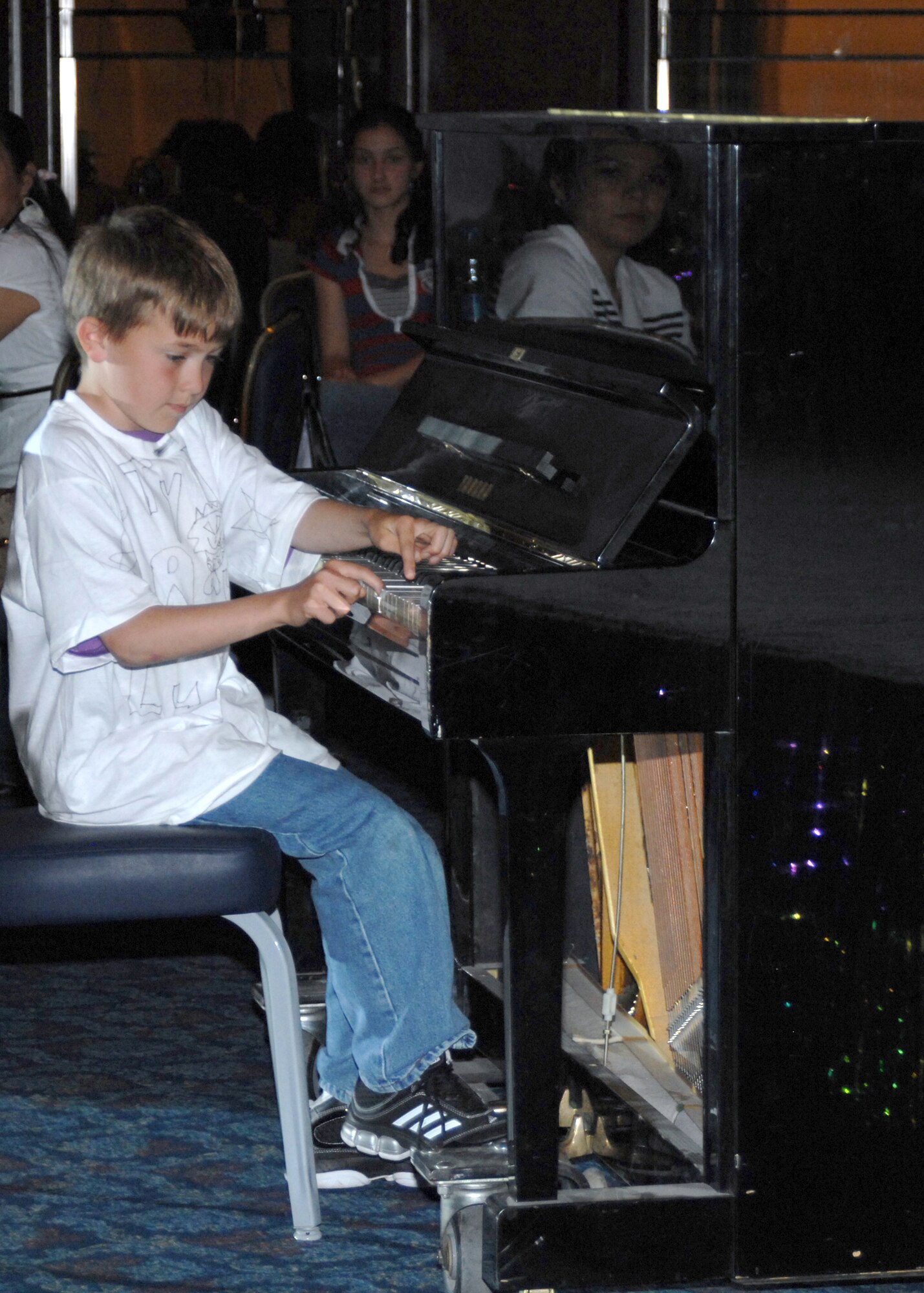 Tylor Luderman performs a piano piece that earned him first place Instrumental Solo for the 6-11 age group. The participants of the talent show were part of a youth center workshop during spring break. The children only had four days of practice before the show. (U.S. Air Force photo by Senior Airman Jason Burton)