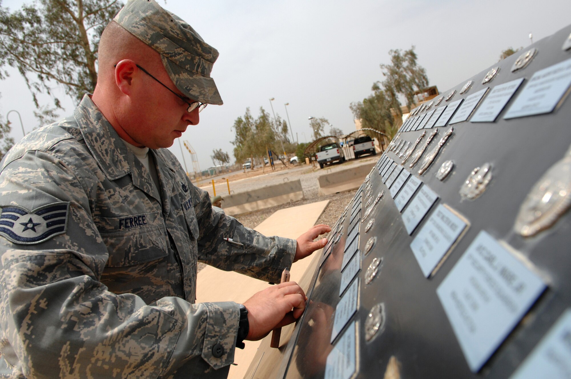 BALAD AIR BASE, Iraq -- Staff Sgt. Karl Ferree, a structural craftsman assigned to the 332nd Expeditionary Civil Engineer Squadron, measures and marks the positions of plaques for the Airman Memorial here, April 16. The memorial is a constant reminder of the price of war and those who have paid the ultimate price for America's freedom and security. The memorial includes the names of all Airmen who have been killed in action since the start of the Global War on Terrorism. Sergeant Ferree is deployed from Luke Air Force Base, Ariz. (U.S. Air Force photo/ Senior Airman Julianne Showalter)