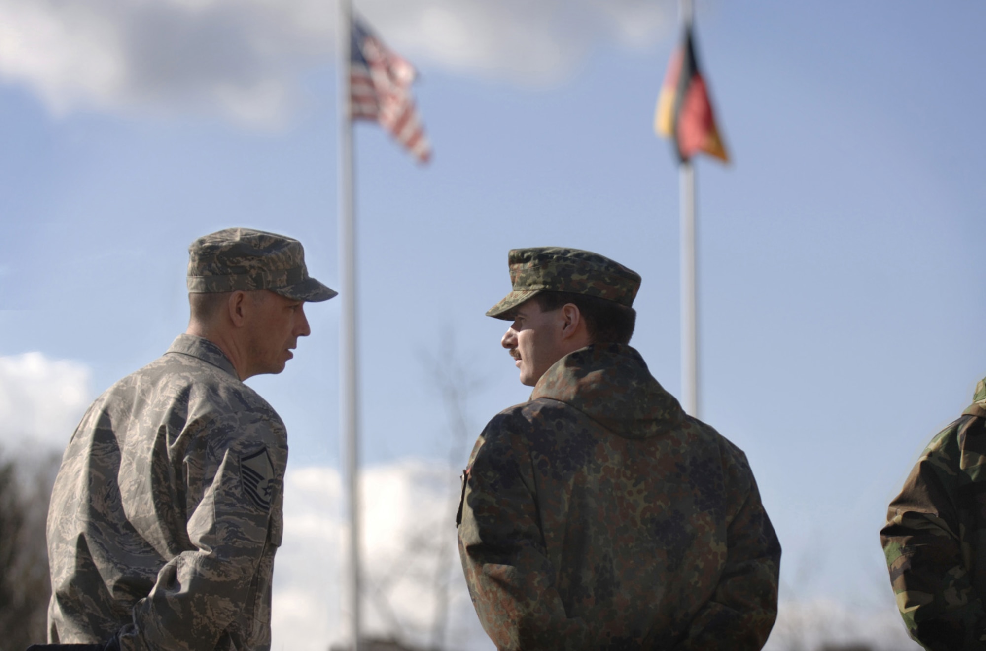 German Air Force Master Sgt. Holger Fels talks with Kisling Noncommissioned Officer Academy instructor, Master Sgt. Karcher Wild before observing a retreat ceremony at Kapaun Air Station, Germany. Sergeant Fels, a German NCO Academy instructor in Appen, Germany, voluntarily enrolled in the six-week academy course designed for U.S. Air Force technical sergeants to prepare for a four-year special duty assignment as an exchange instructor at the Senior NCO Academy at Maxwell Air Force Base, Alabama. Photo by Master Sgt. Scott Wagers