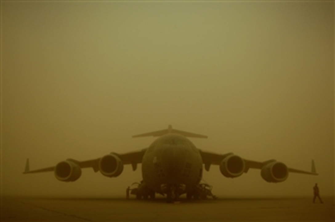 U.S. Air Force 1st Lt. Matheew Lundeen (left) and Maj. Mark Thompson, both pilots from the 817th Expeditionary Airlift Squadron, Mildenhall Air Base, England, walk around their C-17 Globemaster III aircraft while it is parked on the flight line at Sather Air Base, Iraq, during a dust storm on April 17, 2008.  The dust storm reduced visibility to 100 meters and stopped all air traffic from landing at Sather Air Base.  