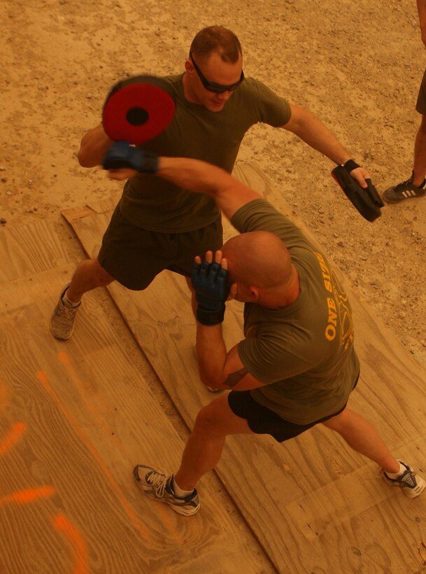 Lt. Timothy J. Rajcevich, 25, from Waukegan, Ill., who is the civil affairs team leader, and Cpl. Brendan A. Ryan, 26, from Hammond, Ind., who is a civil affairs noncommissioned officer with Civil Affairs Team 3, Detachment 1, 2nd Battalion, 11th Marine Regiment, Regimental Combat Team 5, make good use of a sandstorm to workout with some sparring drills in Hit, Iraq, May 6. While they are deployed to Iraq for a year, many of the Marines with CA Team 3 are using their down time to get into the best shape they can.  As extra motivation, they post pictures and videos of themselves working out onto a Web site so their family can see their improvements.