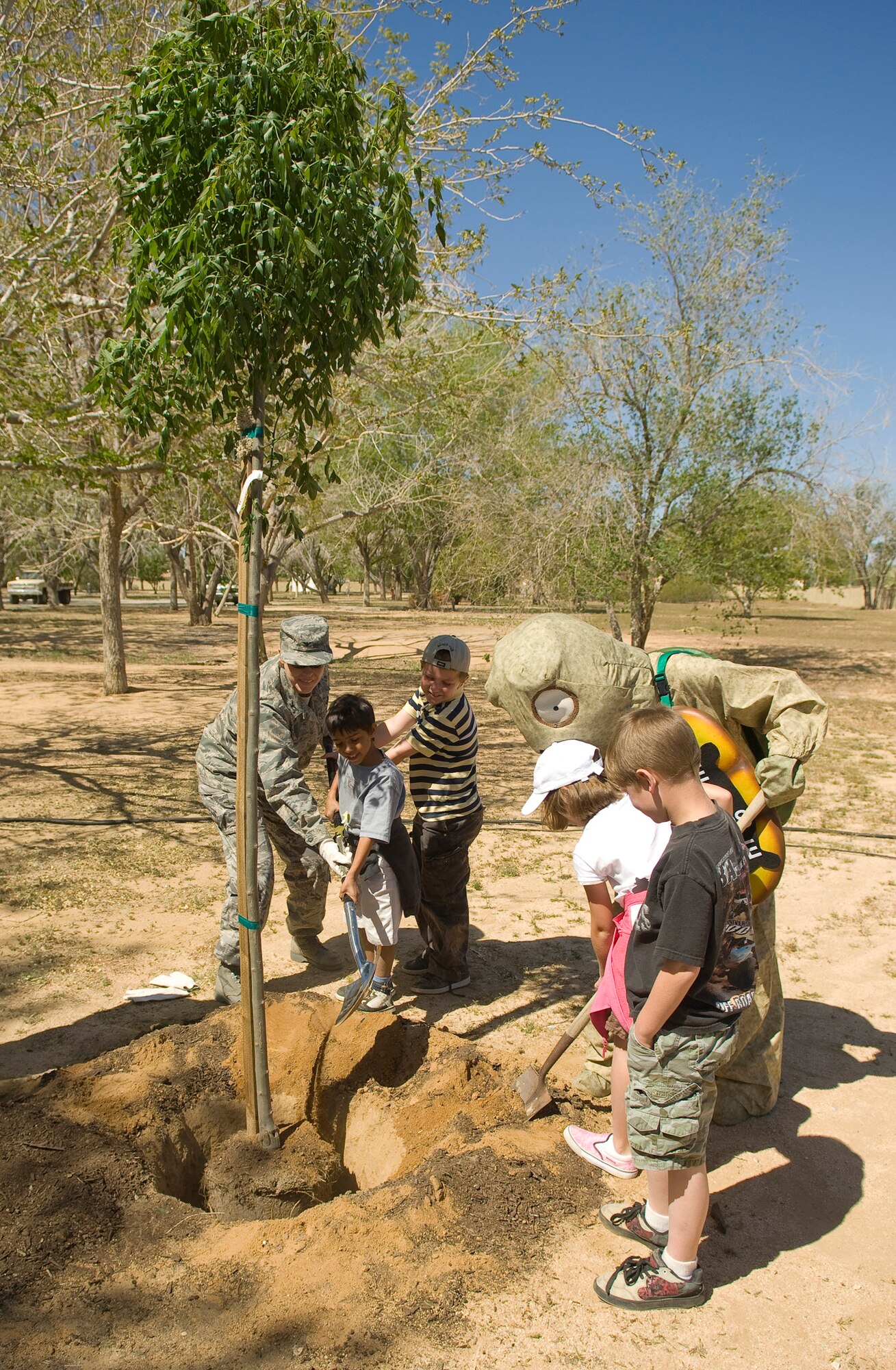 Col. Nancy Wharton (left), 95th Air Base Wing commander, together with base children and Eddie, the Edwards tortoise, plants a tree during the Earth Day celebration here April 17. The Environmental Management holds Earth Day every year to inform the community about the base's conservation efforts. (Air Force photo by Mike Cassidy)