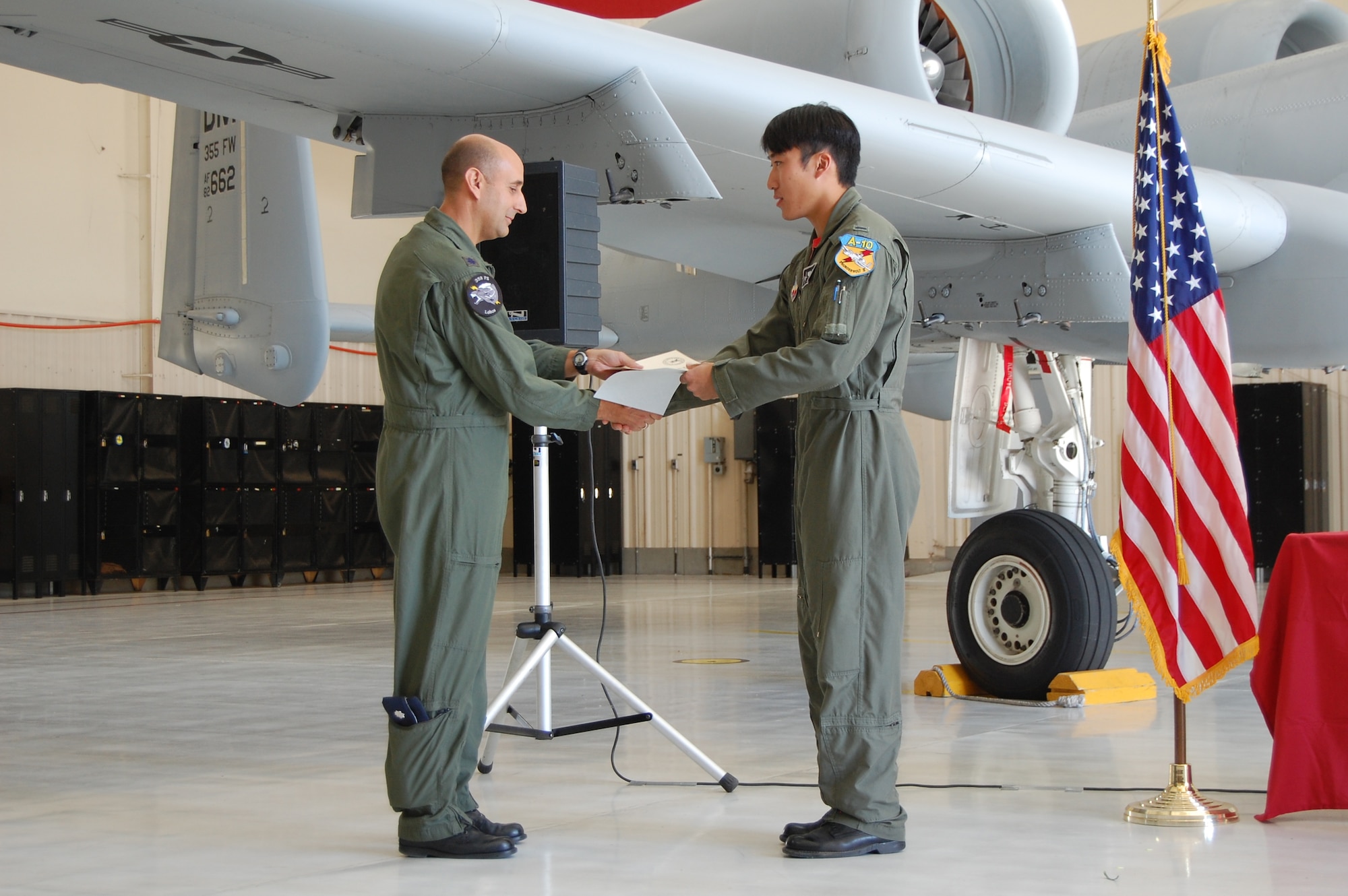 1st Lt. Albert “Juice” Chang, class 08-ABD graduate, accepts his certificate from Lt. Col. Darren Hansen, 358th Fighter Squadron commander, at the initial A-10 qualification course graduation April 11 here.  Lieutenant Chang, a 2005 U.S. Air Force Academy graduate, will be assigned to the 25th Fighter Squadron at Osan Air Base in the Republic of Korea. (U.S. Air Force photo by 2nd Lt. Mary Pekas)