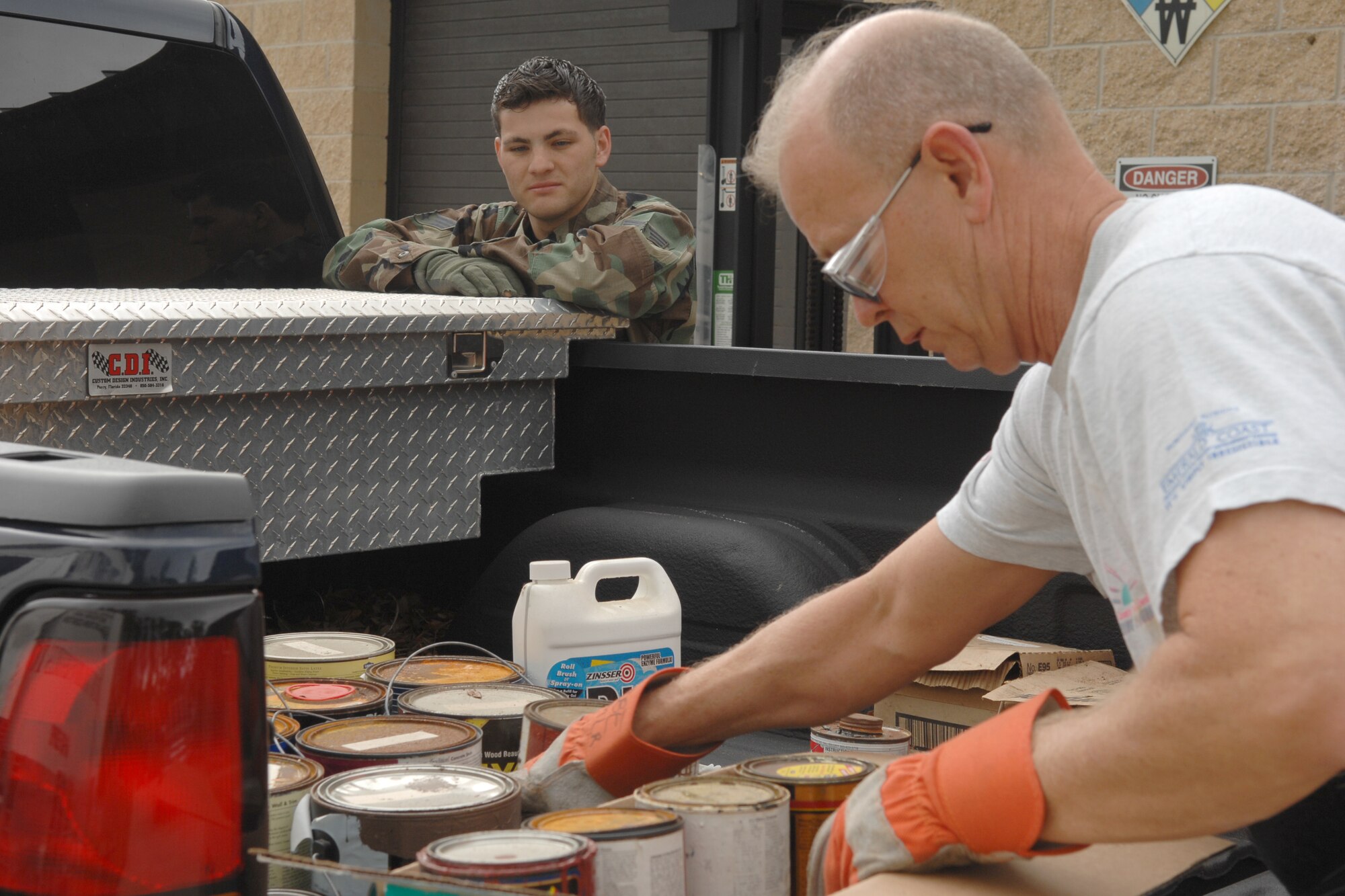 A hazardous waste collection employee at Hurlburt Field collects old paint an Airman brought in during the semi-annual household hazardous waste collection day April 18. This service is offered twice a year in April and October and gives employees and residents of Hurlburt a chance to properly dispose of hazardous items such as paint, autmobile chemicals and flourescent light bulbs. (U.S. Air Force photo/Senior Airman Sheila deVera)