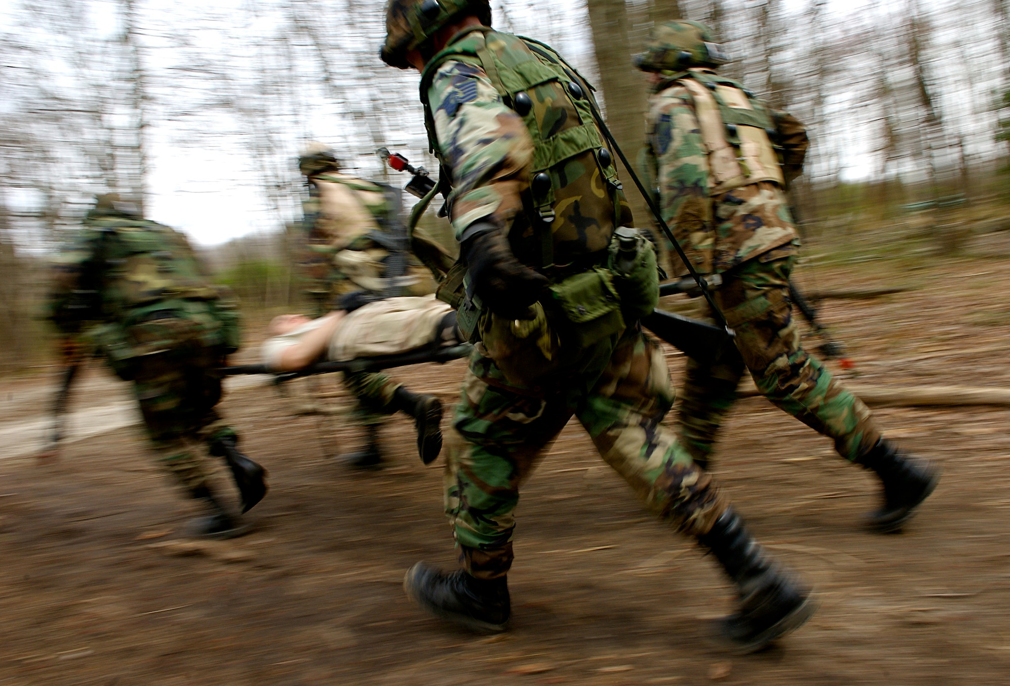 Staff Sgt. Aaron Mills (rear left), Senior Master Sgt. Robert Mayor (rear right) and Staff Sgt. Stephen Price (front right), all students  in Advanced Contingency Skills Training Course 08-4, carry a simulated wounded patient  to safety while taking incoming fire from opposing forces during the combat first aid portion of the ACST course on a Fort Dix, N.J., range April 11, 2008.  The course is taught by the U.S. Air Force Expeditionary Center's 421st Combat Training Squadron and prepares Airmen for upcoming deployments. (U.S. Air Force Photo/Staff Sgt. Samuel Rogers)