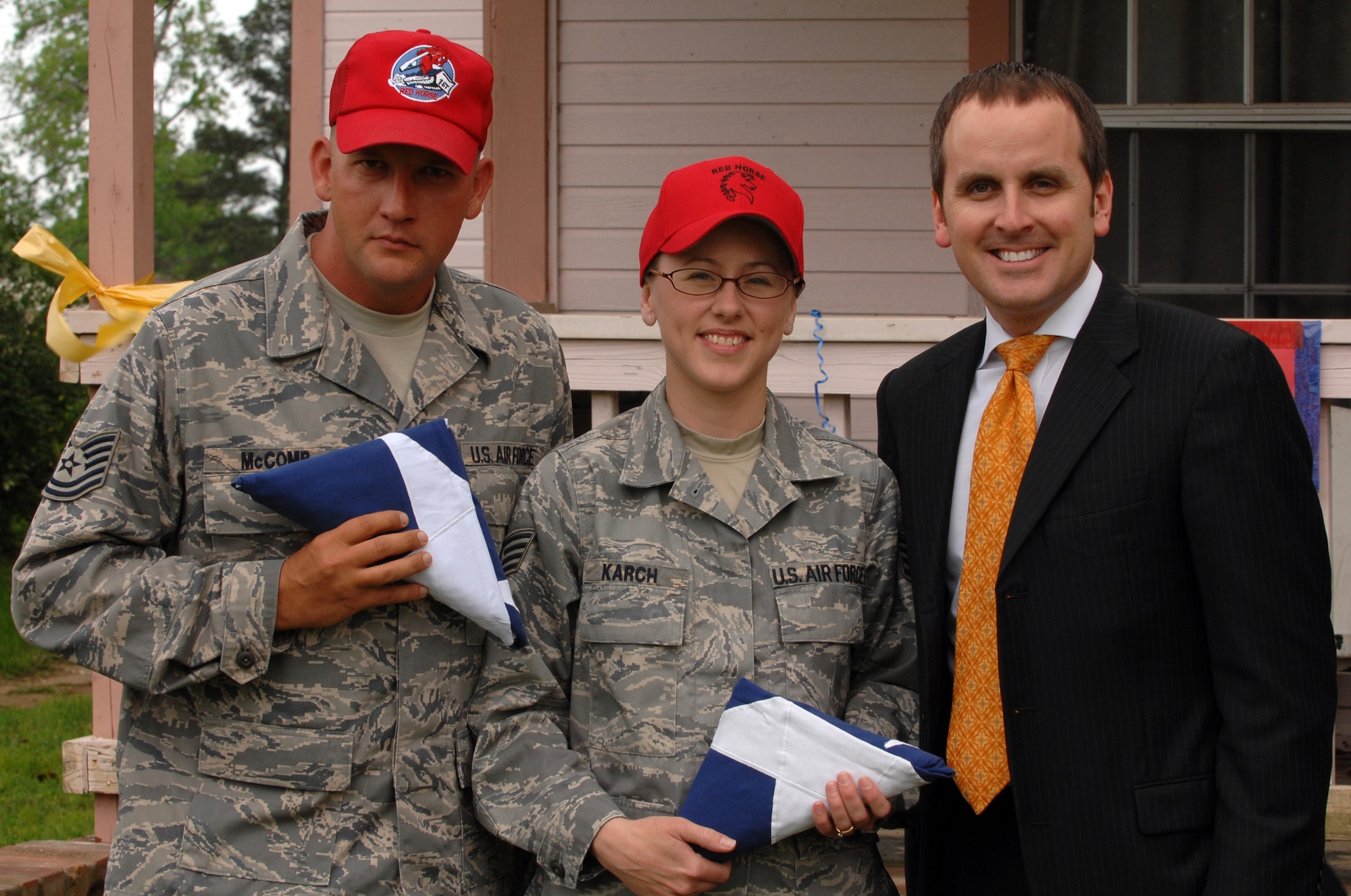 Tech. Sgt. Michael McComb and Staff Sgt. Cynthia Karch show off their Texas state flags presented to them by State Representitive of District Five, Bryan Hughes  in Hawkins, Texas, on April 17th. A parade and award presentation was held for Sergeants McComb and Karch who both recently returned from Iraq and are residents of Hawkins. (U.S. Air Force photo by Airman 1st Class Joanna M. Kresge)