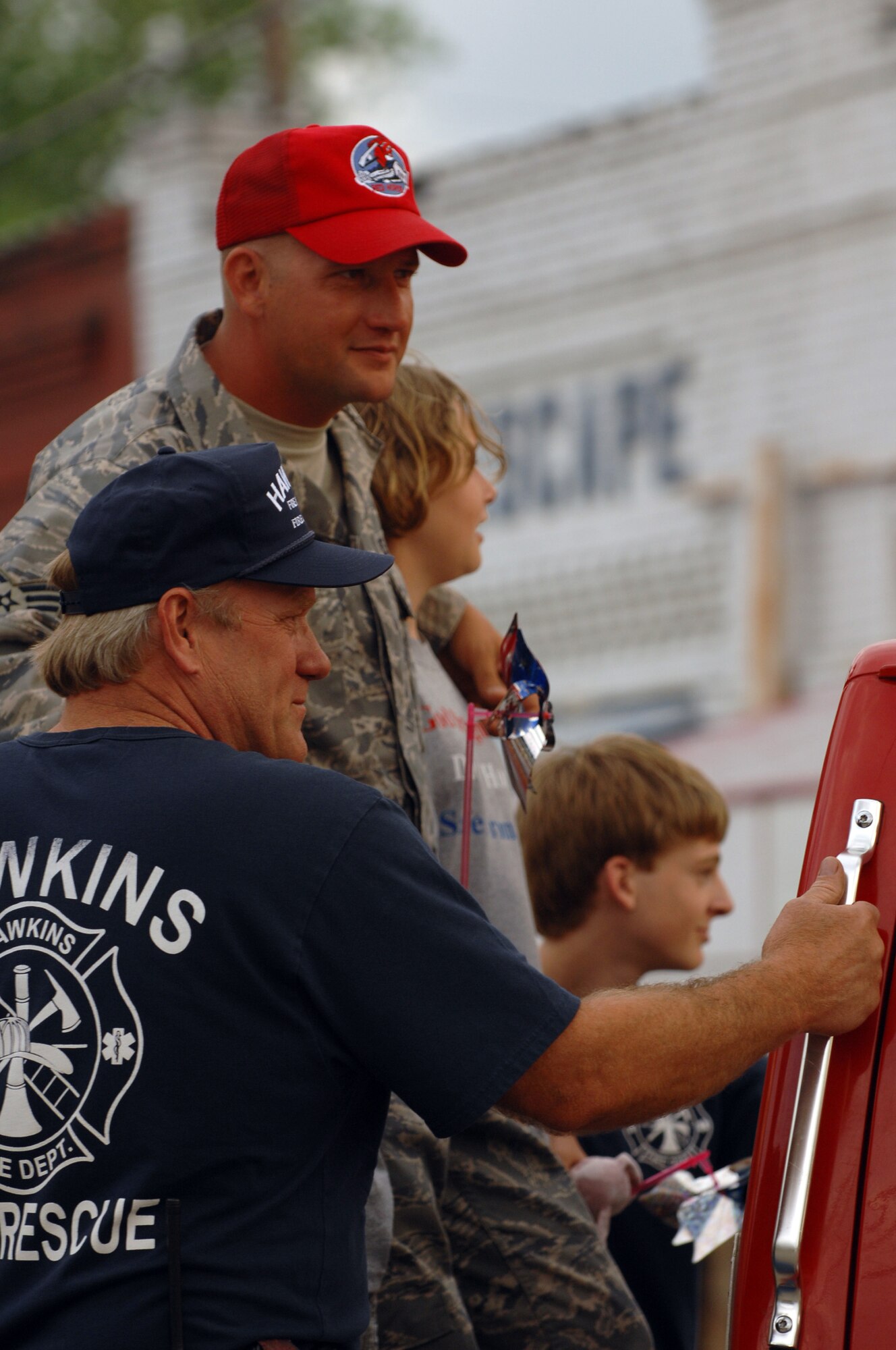 Tech. Sgt. Michael McComb of 307th RED HORSE Squadron rides down the streets of Hawkins, Texas in a fire truck with his children during a hometown hero celebration held here April 17th. A parade and award presentation was held for Sergeant McComb and Staff Sgt. Cynthia Karch who are both members of RHS recently returned from Iraq and residents of Hawkins. (U.S. Air Force photo by Airman 1st Class Joanna M. Kresge)