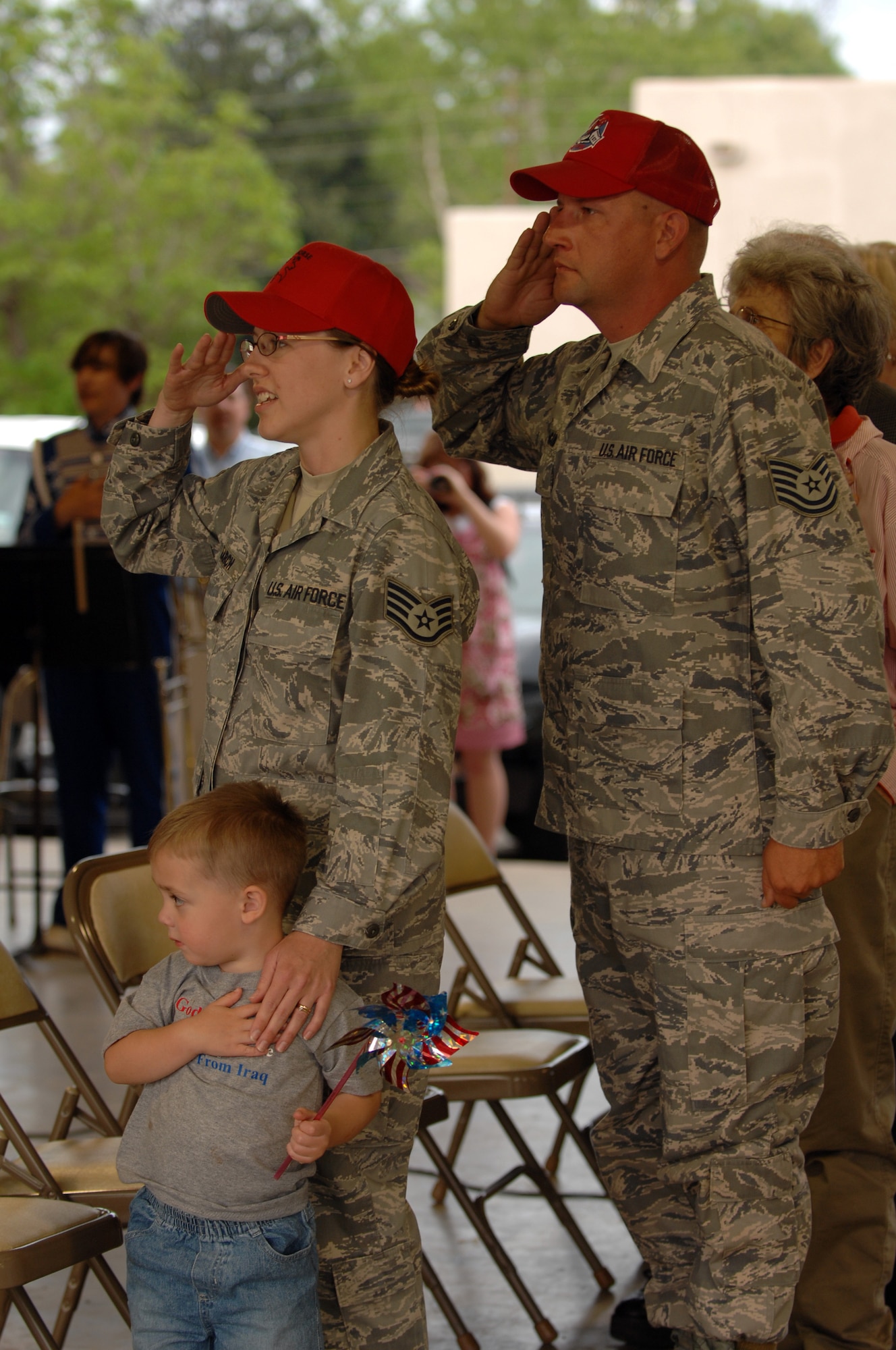Staff Sgt. Cynthia Karch and Tech. Sgt. Michael McComb salute the flag of the United States during the playing of the national anthem in Hawkins, Texas, on April 17th. A parade and award presentation was held for Sergeants McComb and Karch who are both members of RHS recently returned from Iraq and residents of Hawkins. (U.S. Air Force photo by Airman 1st Class Joanna M. Kresge)