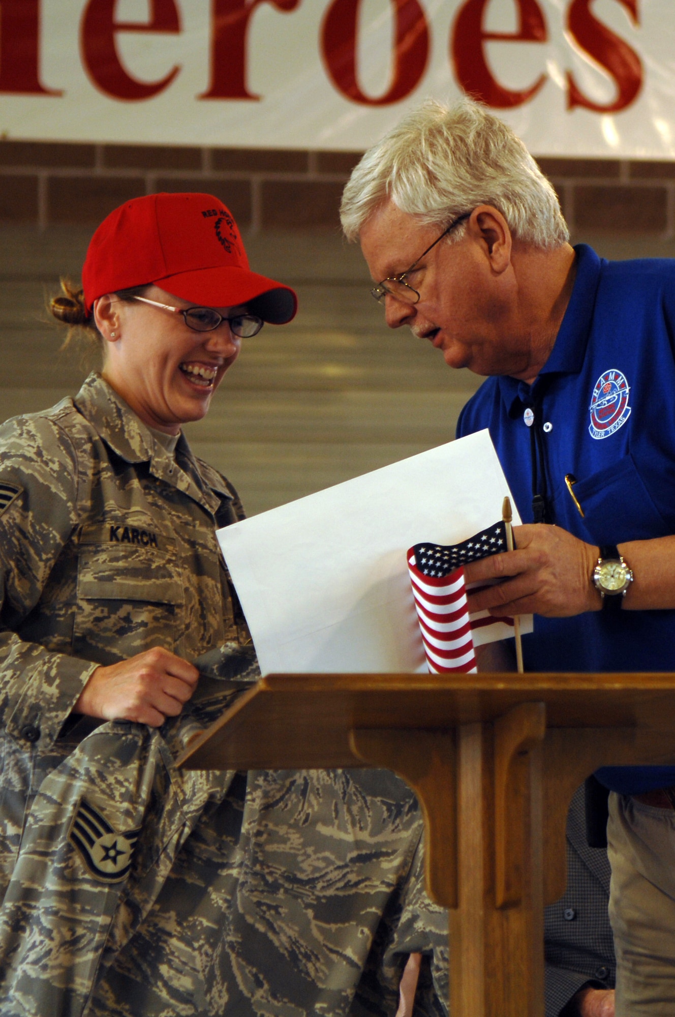 Staff Sgt. Cynthia Karch of 307th RED HORSE Squadron presents a pair of her airman battle uniform to Mike Burke the curator of the Historical Aviation Museum, during a hometown hero celebration held in Hawkins, Texas, on April 17th. Sergeant Karch and Tech. Sgt. Michael McComb who are both members of RHS and residents of Hawkins were honored with a parade and award presentation by their family, friends, and neighbors. (U.S. Air Force photo by Airman 1st Class Joanna M. Kresge)