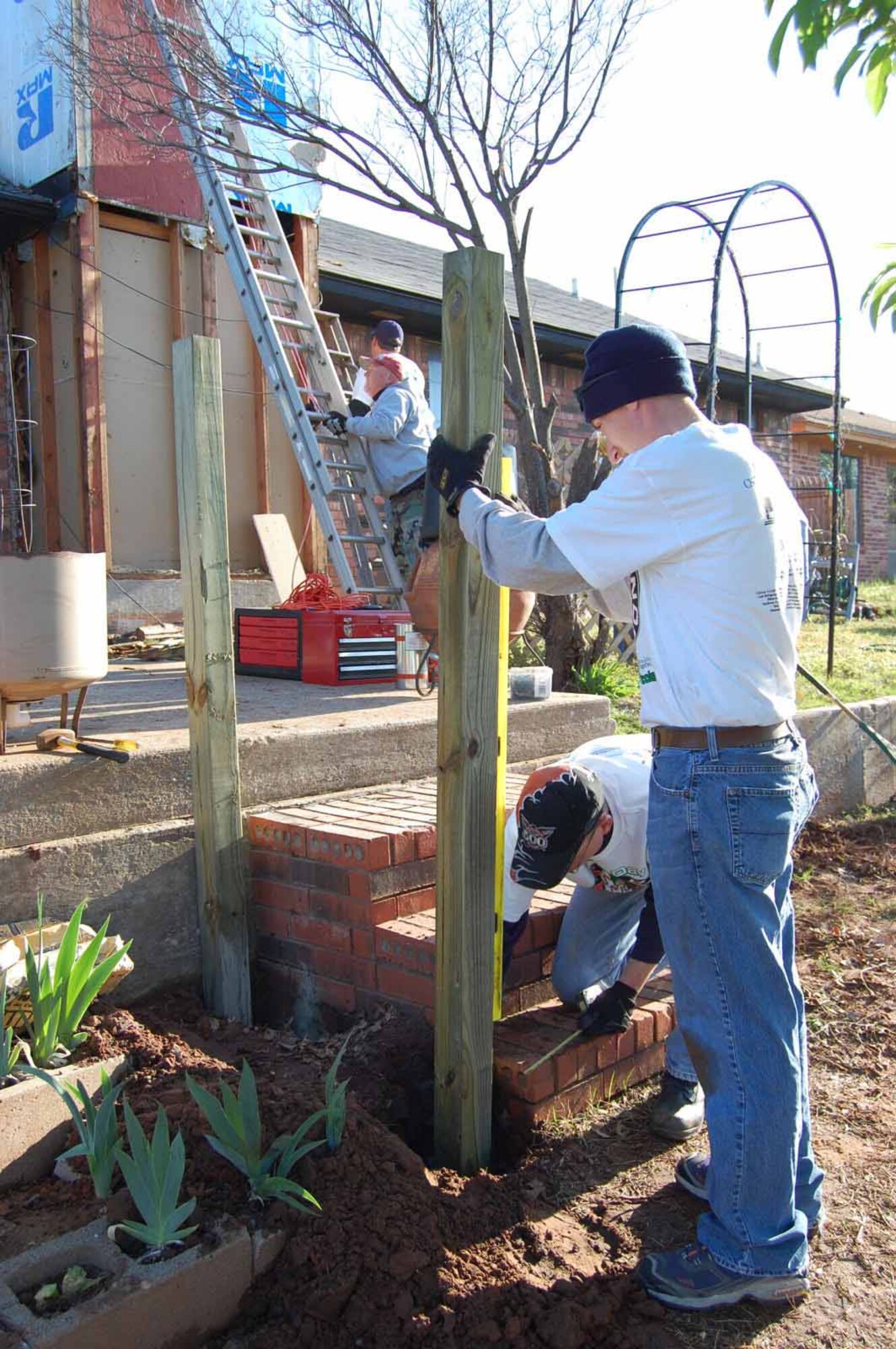 Setting posts for a new ramp at a Midwest City home requires precision leveling by Tinker Management Association volunteers during the Rebuilding Together National Rebuilding Day April 12.  (Air Force photo by Amy Schiess)

