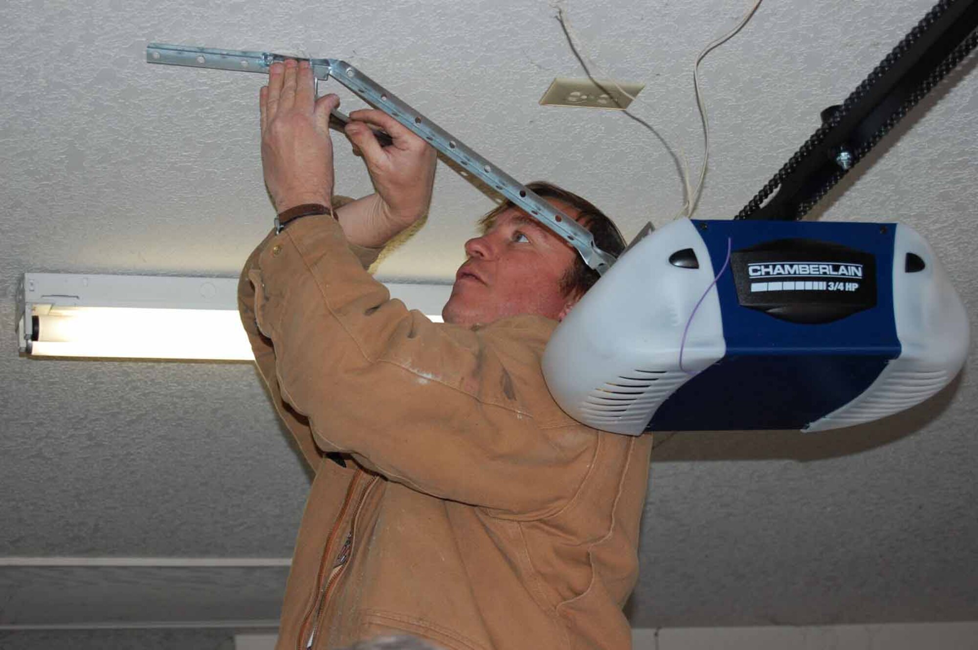 Paul Logan, from the 72nd Air Base Wing, works on replacing the garage door opener of a Midwest City home.  (Air Force photo by Amy Schiess)