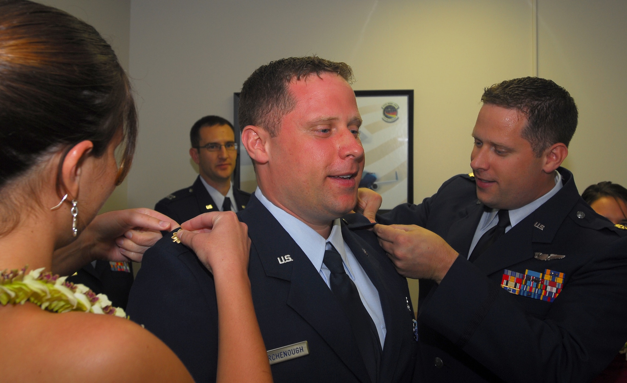 MacKenzie Collatz (left) and newly promoted Maj. Peter Birchenough (right), 65th Airlift Squadron pin the rank of Major on Dennis Birchenough, Air Force Institute of Technology, during a promotion ceremony at the 65th Airlift Squadron conference room.  The majors are identical twins who were promoted to Major on the same day. 