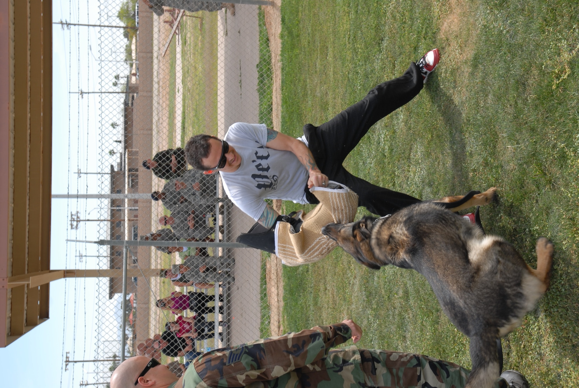Chester Bennington from Linkin Park attempts to free himself from a military working dog's bit during a visit to Luke April 1. He didn't get very far. (U.S. Air Force photo by A1C Chris Hatch)