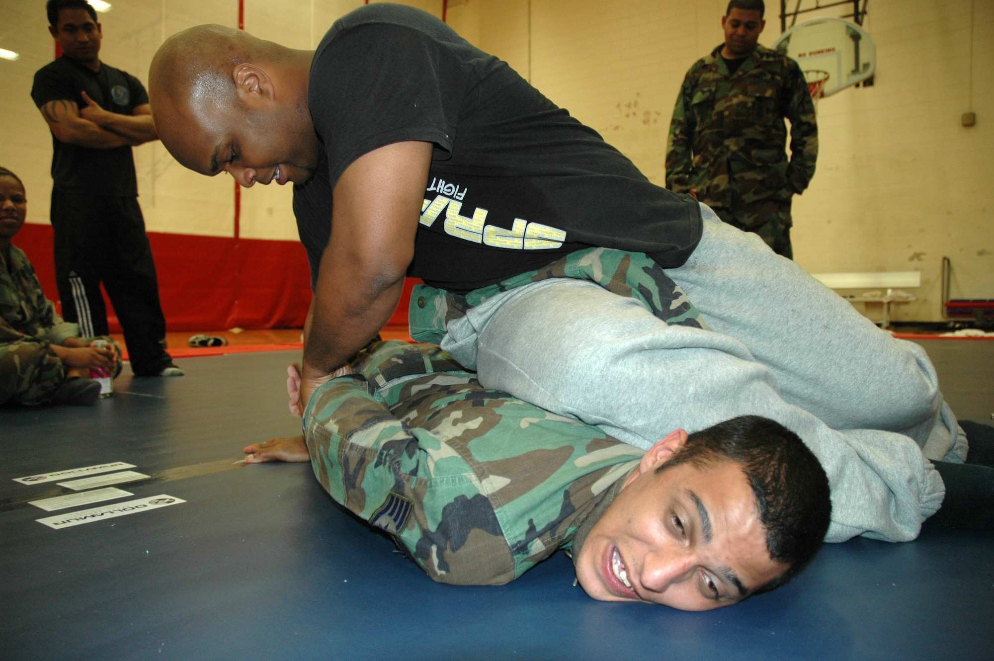 Carlos Cummings, martial arts instructor and owner of Cummings Combat Sambo, puts Staff Sgt. Michael Blount, 325th Security Forces Squadron patrolman, into a combative move at the fitness center here Friday.  Mr. Cummings was on base to teach patrolmen from the the 325th SFS a self-defense course designed to teach combatives and other techniques to help them with both home station and deployed missions.  (U.S. Air Force photo/Staff Sgt. Timothy R. Capling)