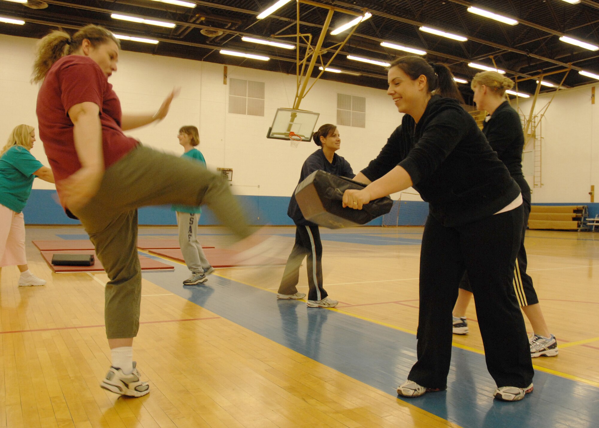 CANNON AIR FORCE BASE, N.M. -- Monique Wall practices a kick with her partner Andrea Weaver during a self defense class at the Fitness Center April 17.  April is Sexual Assault Awareness month. (U.S. Air Force photo/Airman 1st Class Evelyn Chavez)