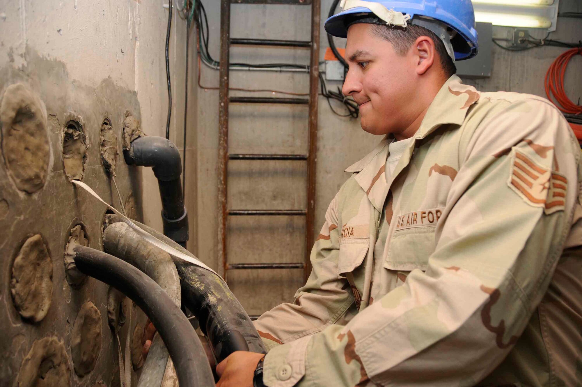 Staff Sgt. Simon Garcia, 379th ECS noncommissioned officer in charge of cable and antenna communications systems, does quality assurance tests on recently-installed 1800 pair copper wire. He is looking for discrepancies such as kinks in cable, which can cause problems in the longevity of the individual cables inside. The wire supports up to 1,800 phone and data lines in the Blatchford-Preston Complex. (U.S. Air Force photo/Senior Airman Domonique Simmons)