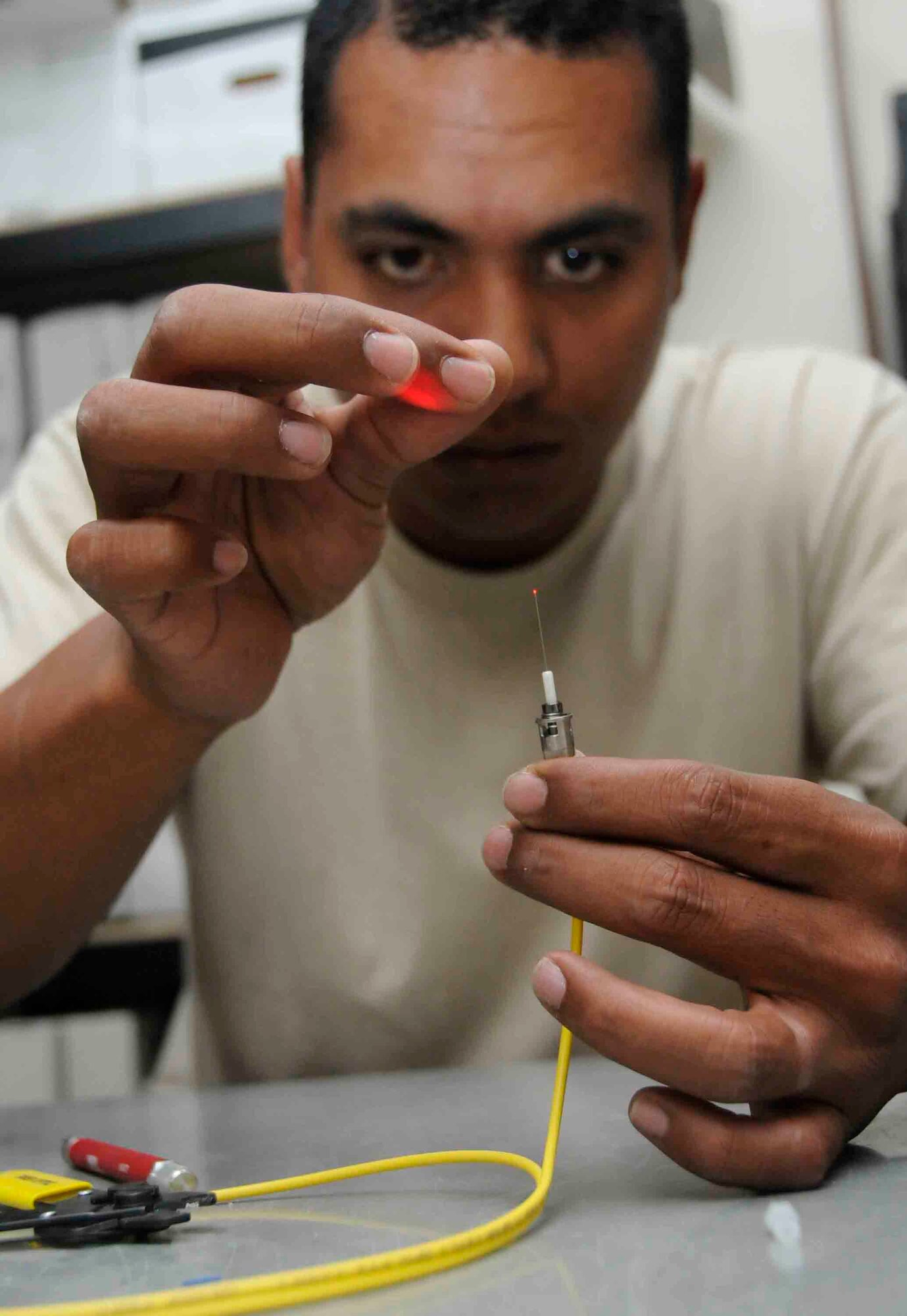 Staff Sgt. David Reyes, 379th Expeditionary Communications Squadron cable and antenna communications system specialist, puts a hot melt patch kit onto a single mode fiber to have communication connectivity between a switch and patch panel onto the user. A single strand of fiber can support up to 900 communication lines with the proper multiplexer. (U.S. Air Force photo/Senior Airman Domonique Simmons)