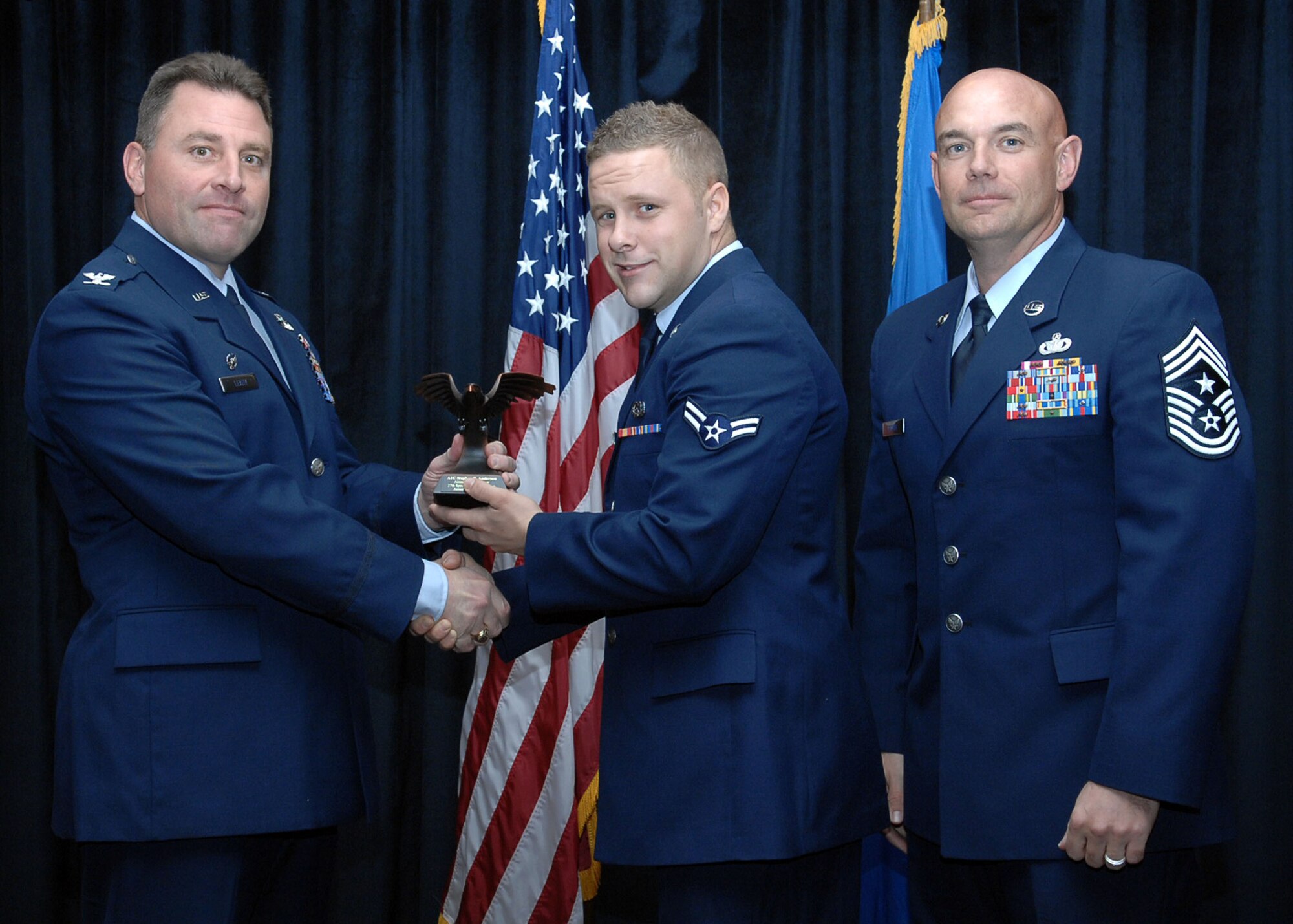 CANNON AIR FORCE BASE, N.M. - Airman 1st Class Stephen Anderson, 27th Special Operations Equipment Maintenance Squadron, receives the  Airman of the Quarter award presented by Col. Timothy Leahy, 27th Special Operations Wing commander, and Chief Master Sgt. Daniel Fischer, 27th Special Operations Wing command chief. (U.S. Air Force photo/Airman Basic Danielle Martin) 