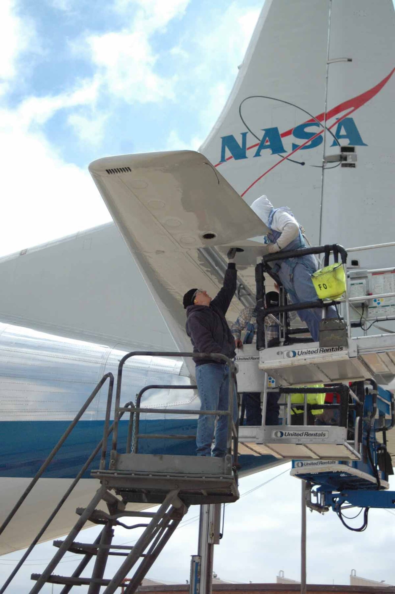 Tinker employees work rapidly to disassemble the rutter of the NASA Guppy in order to get the plane inside before more bad weater hit April 9.  (Air Force photo by Danielle Gregory)