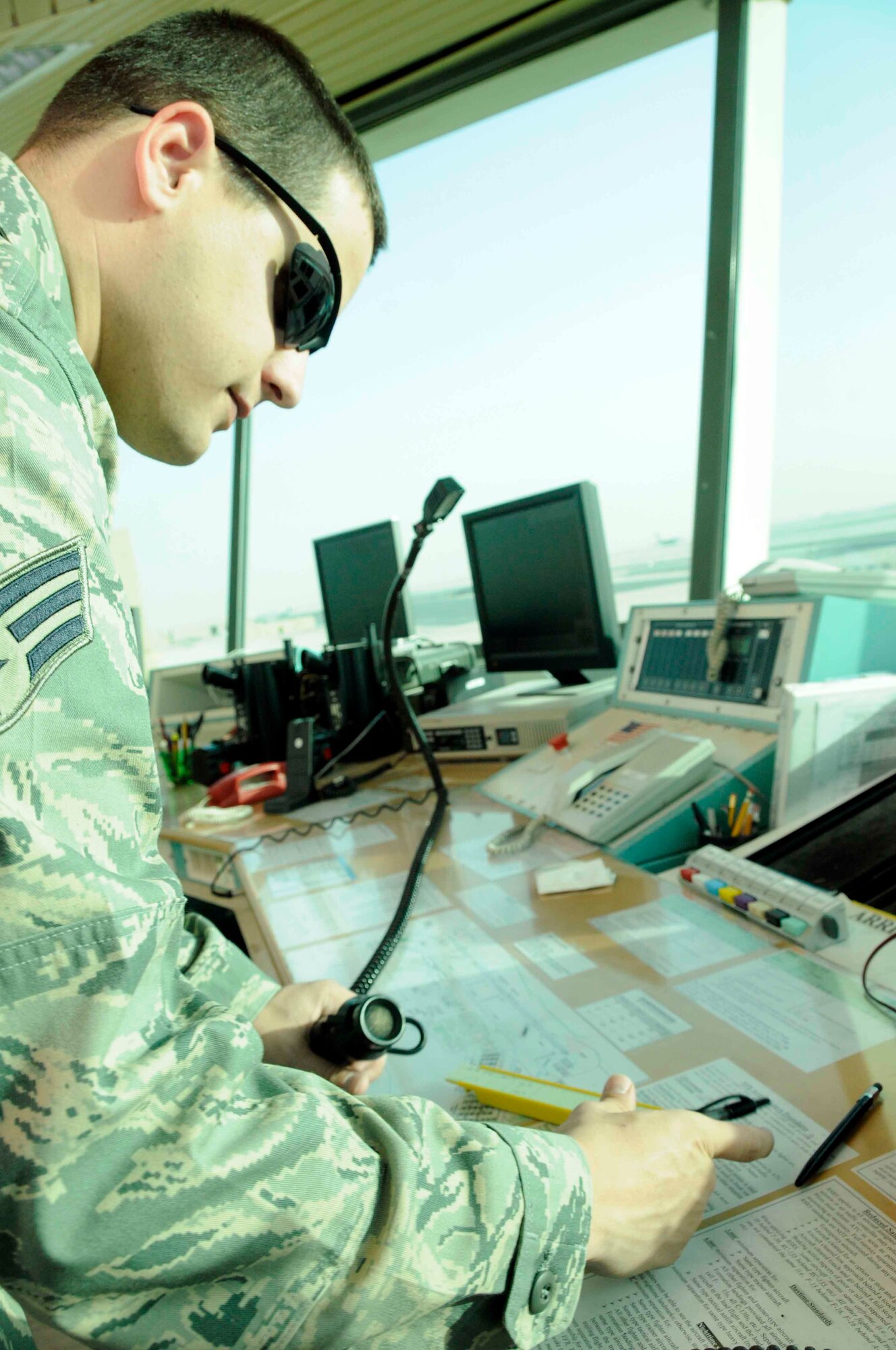 After communicating through radio from the air traffic control tower, Senior Airman Eric Kindle logs an accurate departure time for an aircraft April 15. As an air traffic control journeyman, Airman Kindle is dedicated to the task of ensuring aircraft taking off or landing do so safely and quickly. (U.S. Air Force photo/Senior Airman Domonique Simmons)