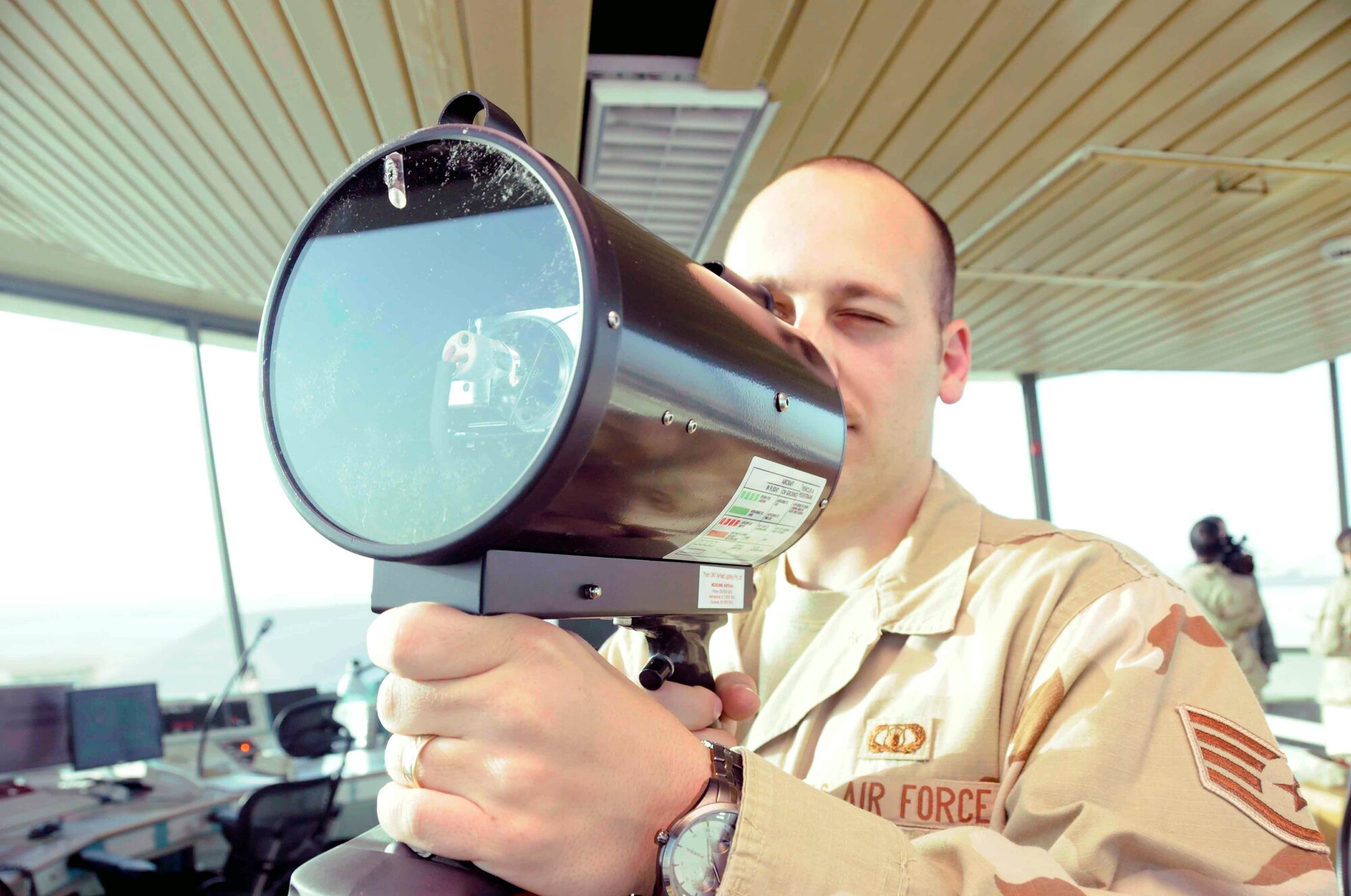 Staff Sgt. Bryce Hamilton demonstrates the use of a light signal to communicate with vehicles that have lost radio contact with the tower. (U.S. Air Force photo/Senior Airman Domonique Simmons)