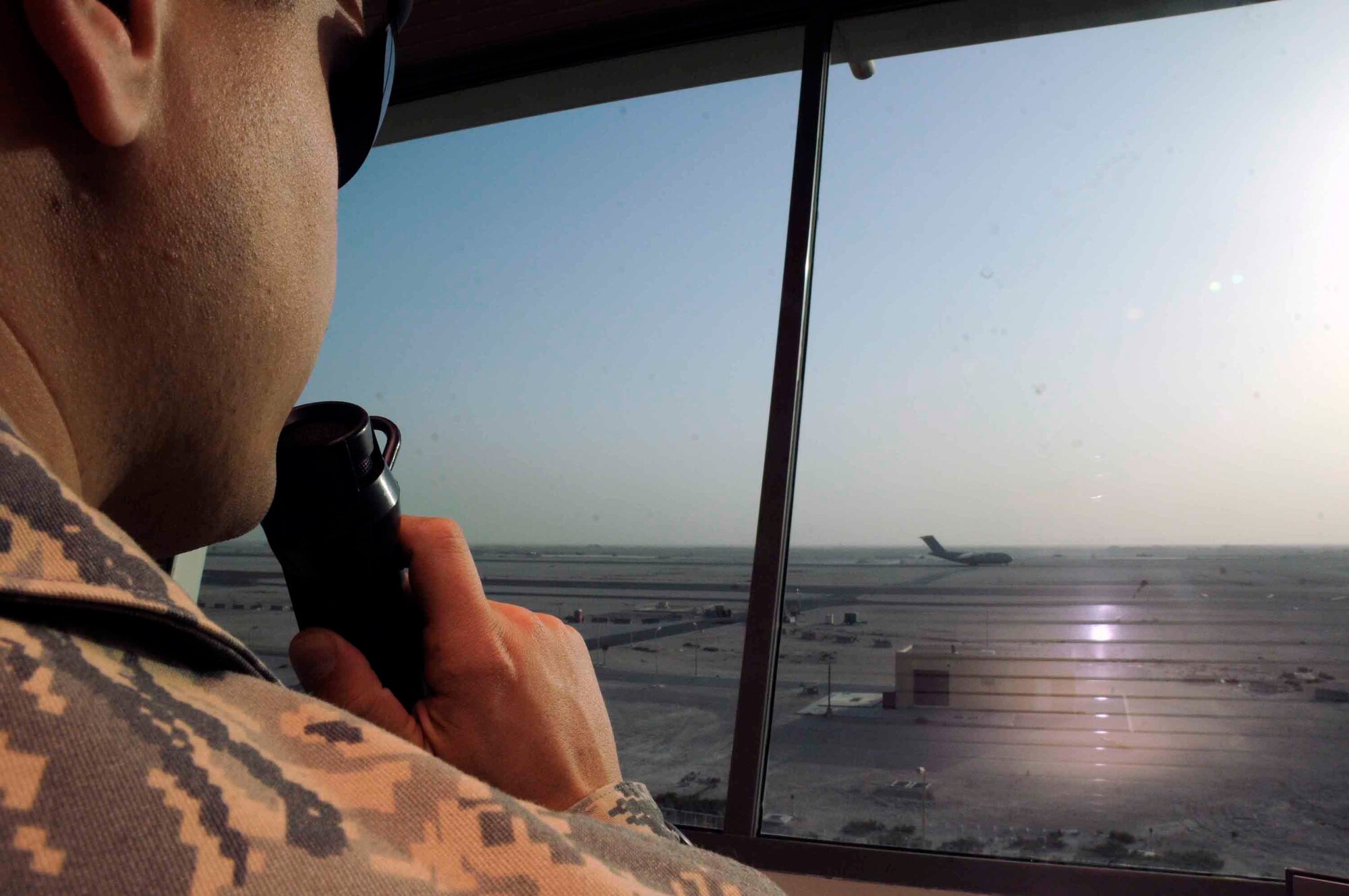 Senior Airman Eric Kindle, air traffic controller journeyman, communicates to aircraft taxiing on the runway through radio channels from the air traffic control tower. (U.S. Air Force photo/Senior Airman Domonique Simmons)