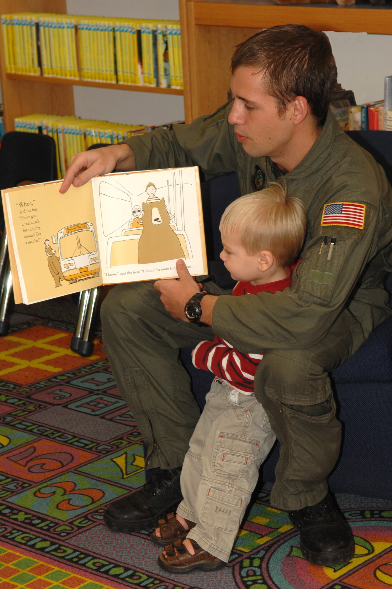 Senior Airman Justin Smith, 4th Special Operations Squadron, reads "A Bear and his Boy" to a group of children at the base library April 17. Four members of the 4th SOS volunteered their time to read to the children and presented each child with a squadron patch and the book "The Giving Tree." (U.S. Air Force photo/Airman 1st Class Kimberly Darnall) 