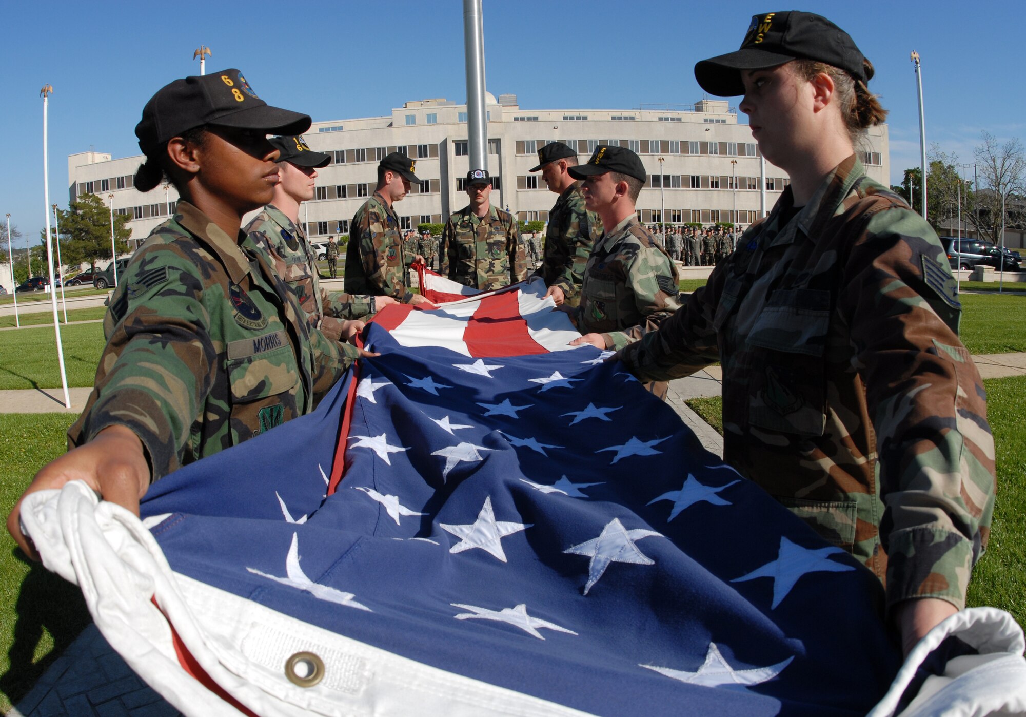 Senior Airman Dietta Morris, 68th Electronic Warfare Squadron, and Staff Sgt. Jacqueline Barker, 16th Electronic Warfare Squadron, hold the flag as its being folded during the base retreat ceremony April 17 at Eglin Air Force Base.  The ceremony was performed by the 53d Electronic Warfare Group, which had three flights representing the three squadrons.  This is the last base retreat ceremony the EWG will perform as part of the 53d Wing.  By October, the group will transition to Air Force Cyber Command.  Photo by Staff Sgt. Samuel King Jr.