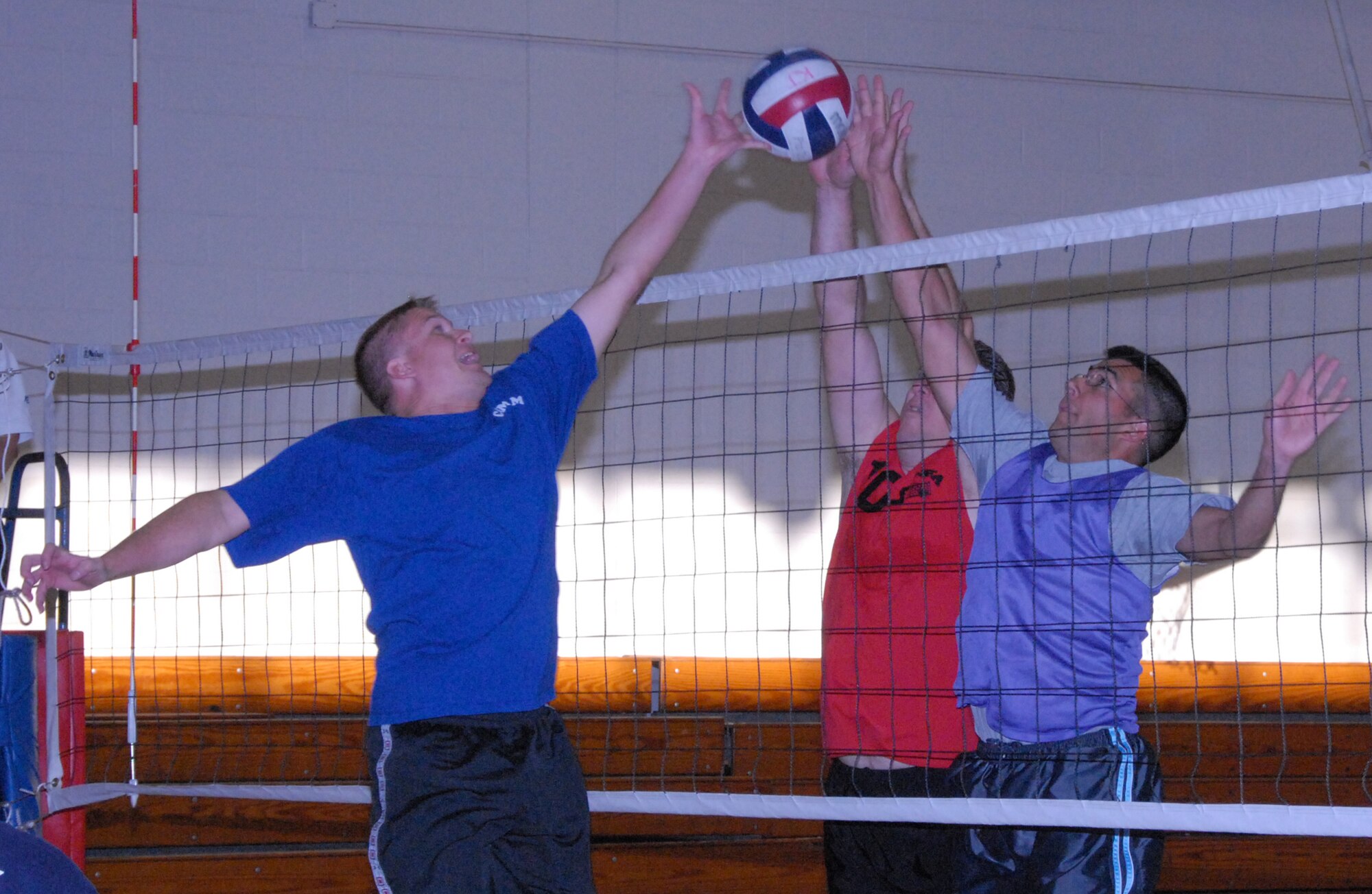 Steven Wagner, 96th Communications Squadron, and Mark Old and Juan Morales, 53d Wing, jump for the ball during a heated intramural playoff game at Eglin Air Force Base, Fla.  The 53d lost a close match to go 9-5 on the year.  The COMM team moved on to play the 33rd Maintenance Squadron in the finals.  Photo by Staff Sgt. Samuel King Jr.