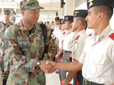 SOTO CANO AIR BASE, Honduras--Air Force Senior Master Sgt. Anthony Kendrick is greeted by a cadet at the Honduran Military Training Academy in Tegucigalpa, Honduras April 16. Sergeant Kendrick briefed senior cadets on the importance continuous enlisted professional military education plays in the career of U.S. military?s enlisted corps. (U.S. Air Force photo by Tech. Sgt. William Farrow) 