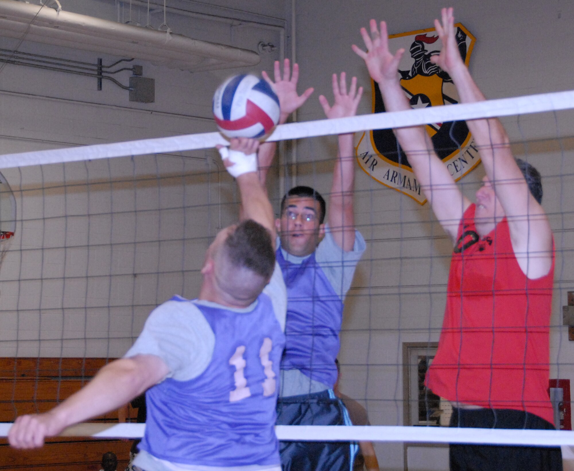 (Left to right) Juan Morales and Mark Old, 53d Wing, move in for a block against a 96th Communications Squadron player April 17 during an intramural playoff game at Eglin Air Force Base, Fla.  The 53d lost a close match to go 9-5 on the year.  The COMM team moved on to play the 33rd Maintenance Squadron in the finals.  Photo by Staff Sgt. Samuel King Jr.