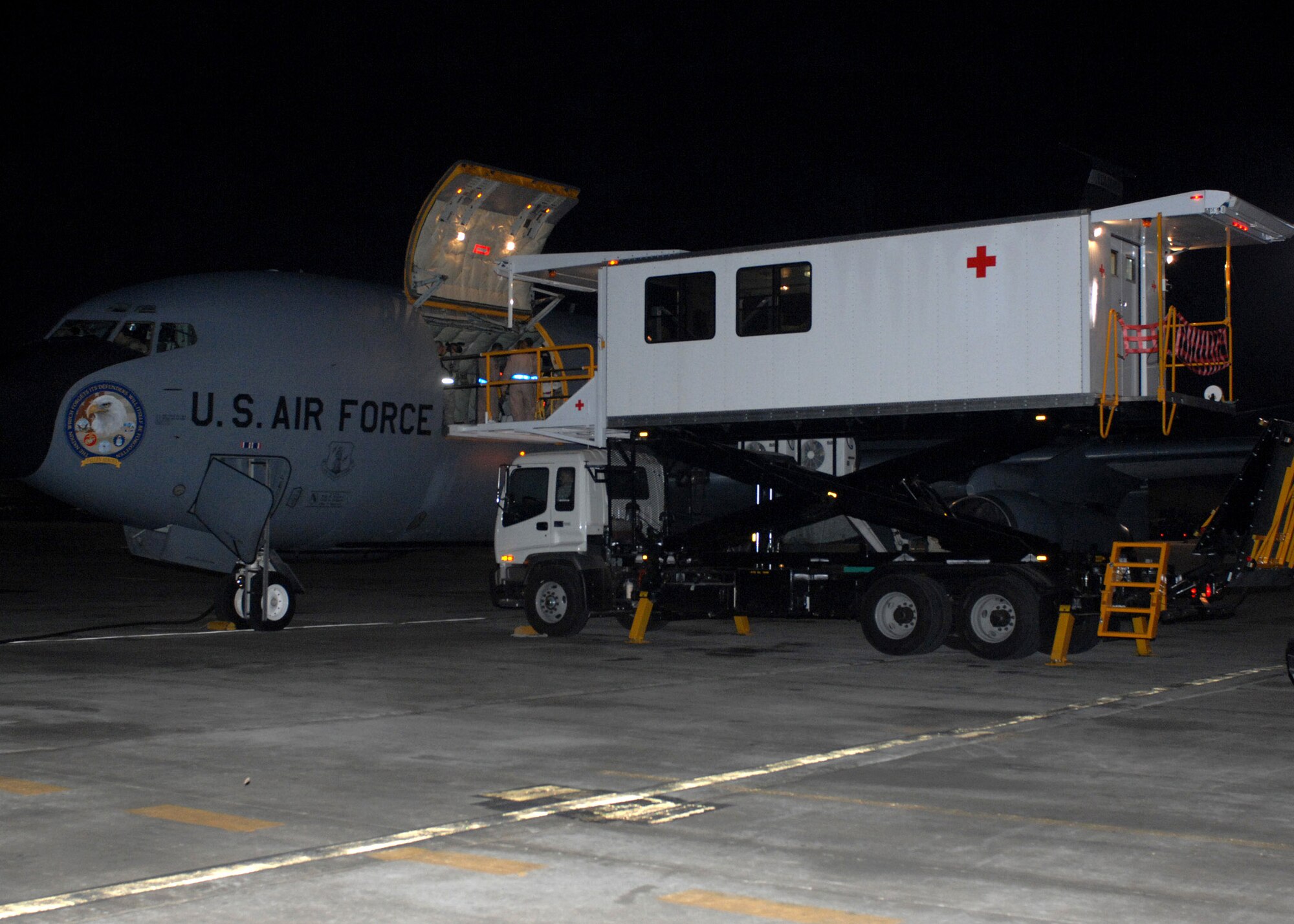 An Air Force high deck patient loading platform aligns with a KC-135 Stratotanker to load patients to be flown to Landstuhl Army Regional Medical Center, Germany, here April 9. The new HDPLP, a special-purpose vehicle which limits the time a patient is exposed to outside elements, is one of three vehicles in the Air Force inventory. (U.S. Air Force photo/Master Sgt. Demetrius Lester)