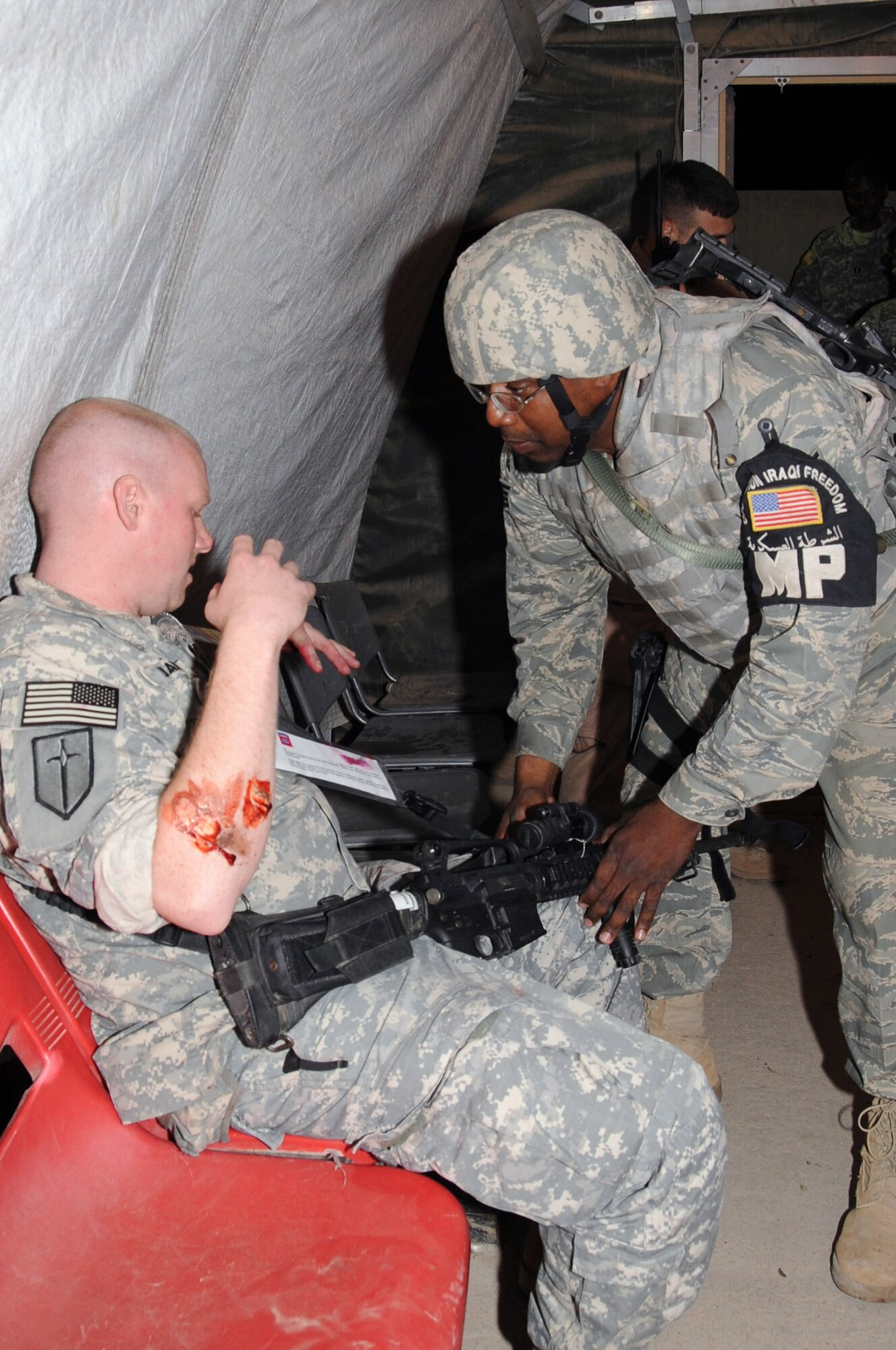 ALI BASE, Iraq -- Staff Sgt. Saleh Harris 407th Expeditionary Security Forces Squadron provost marshal member, assist an injured soldier, Specialist Chris Davis 603rd Transportation Company member during a recent exercise here April 11.  U. S. Air Force Airmen, Army Soldiers, and Romanian infantry came together to sharpen their skills in the case of a mass casualty attack on Contingency Operating Base Adder and Ali Base.  Sergeant Harris is deployed from Robins AFG, Ga. and Specialist Davis is deployed from Fort Polk, La. (U. S. Air Force photo / Tech. Sgt. Sabrina Johnson)