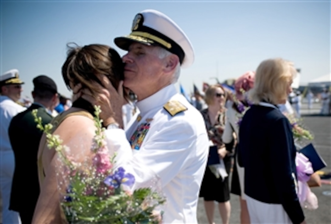 Adm. William J. Fallon kisses his daughter Christi at the end of his retirement ceremony onboard USS Theodore Roosevelt at Norfolk Naval Station, Va., April 18, 2008. 