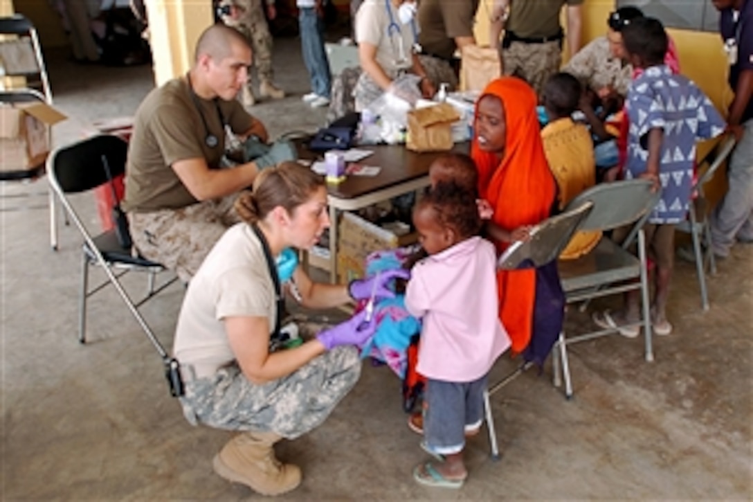 U.S. Army Sgt. Catherine Olivarez takes a boy's temperature during a medical civil action project in Goubetto, Djibouti, on March 30, 2008.  Navy and Marine Corps medical teams from the USS Tarawa Expeditionary Strike Group joined with their Army counterparts from the 354th Civil Affairs Brigade to kick off the six-day project.  