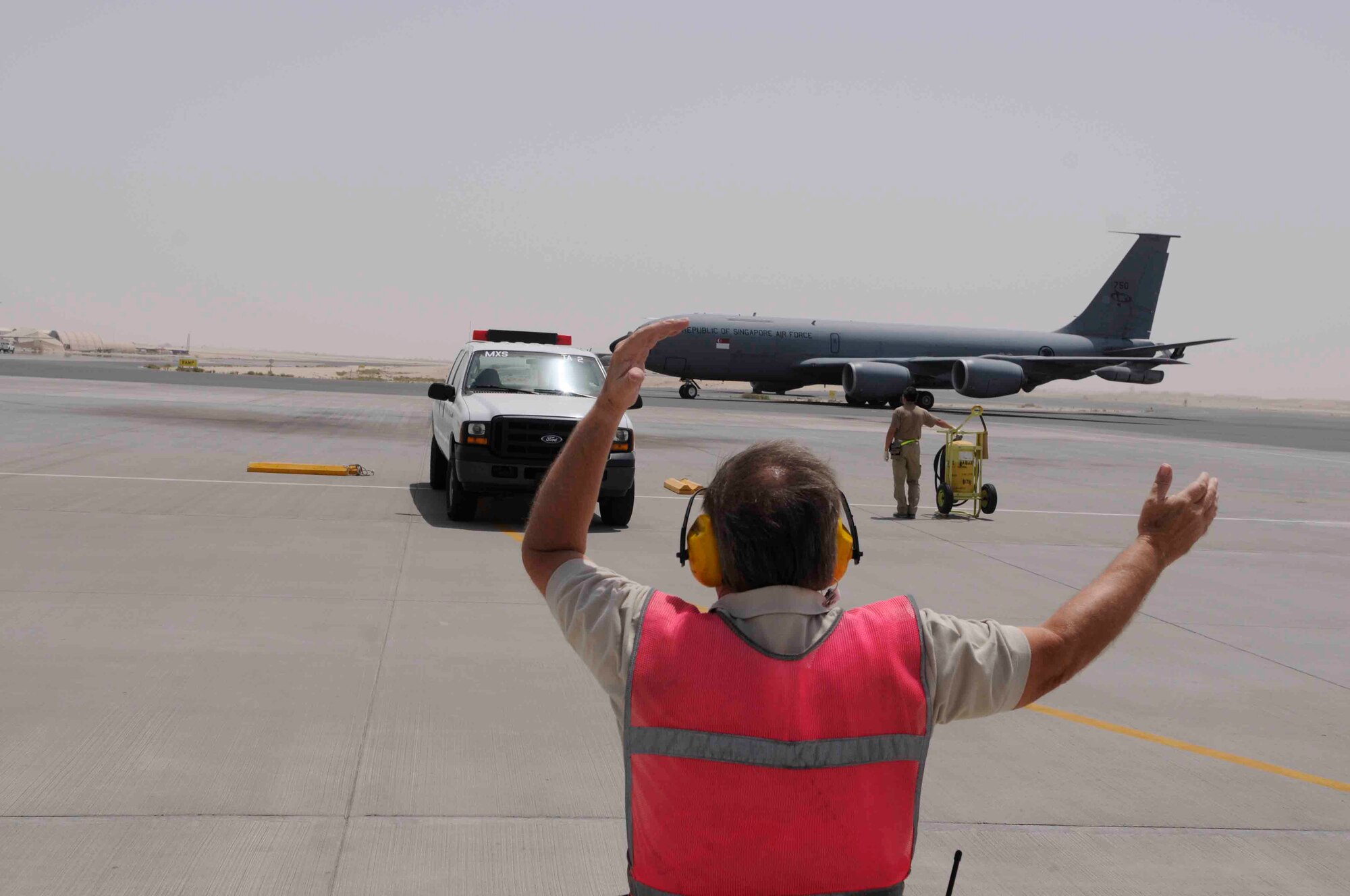 Tom O’Toole, 379th Expeditionary Maintenance Squadron transportation and alert specialist, performs aircraft recovery for a Republic of Singapore Air Force KC-135 here April 16. This is the the RSAF’s 112th Squadron’s fifth deployment rotation since 2004.  As coalition partners, their job is to integrate with tanker operations in the 379th Air Expeditionary Wing, which account for more than half of the refueling support provided throughout the region. (U.S. Air Force photo/Tech. Sgt. Johnny Saldivar)
