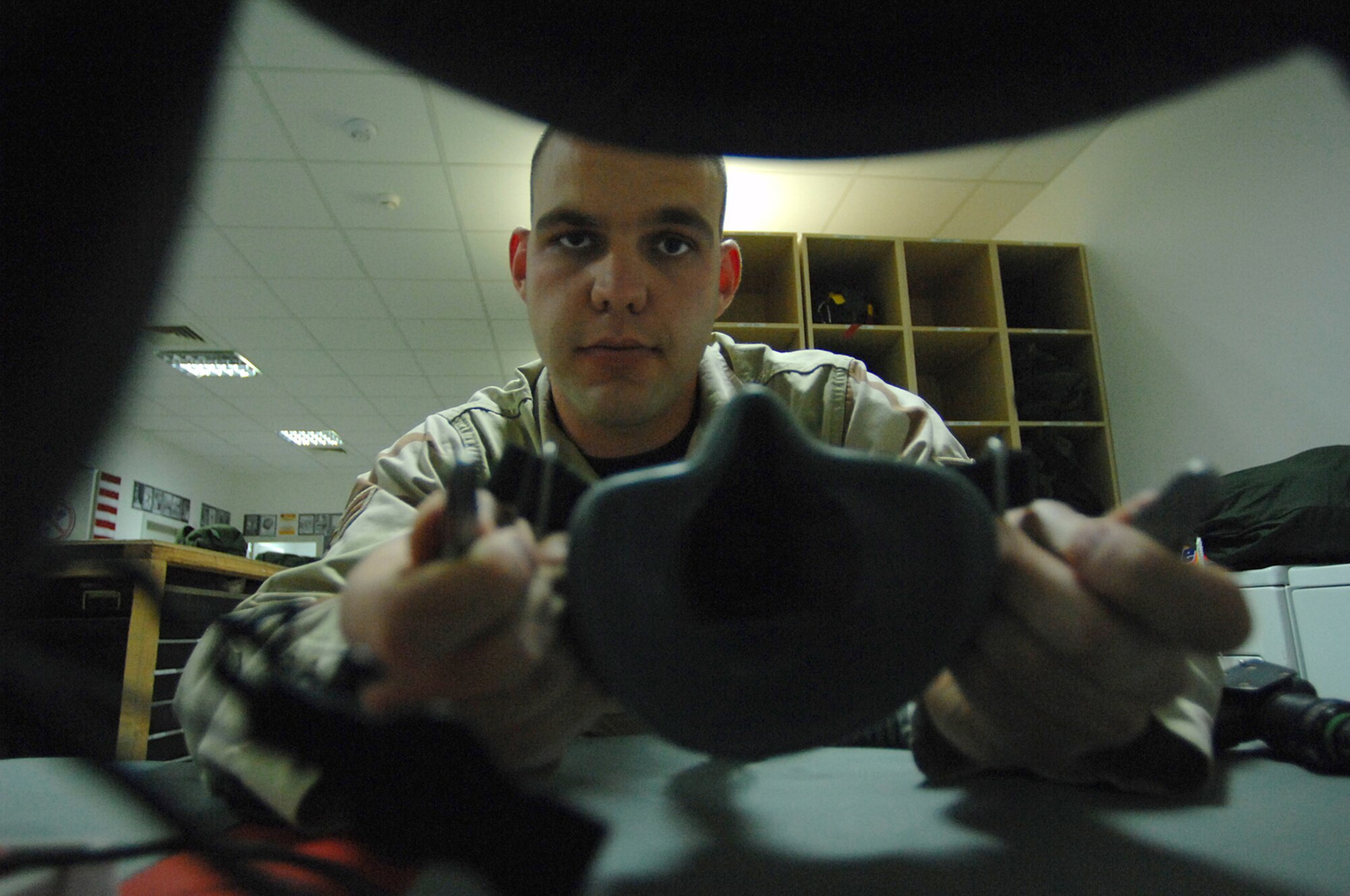 BALAD AIR BASE, Iraq -- Airman 1st Class John Vice, a 777th Expeditionary Airlift Squadron aircrew flight equipment technician, attaches an oxygen mask to a C-130 Hercules aircrew helmet during a 30-day inspection here, April 16. The helmet provides wearers with head and eye protection and helps air crew members communicate with each other. Providing the 777 EAS aircrews with functioning equipment directly affects the success of combat sorties flown everyday. Airman Vice is deployed from Little Rock Air Force Base, Ark. (U.S. Air Force photo/ Senior Airman Julianne Showalter) 