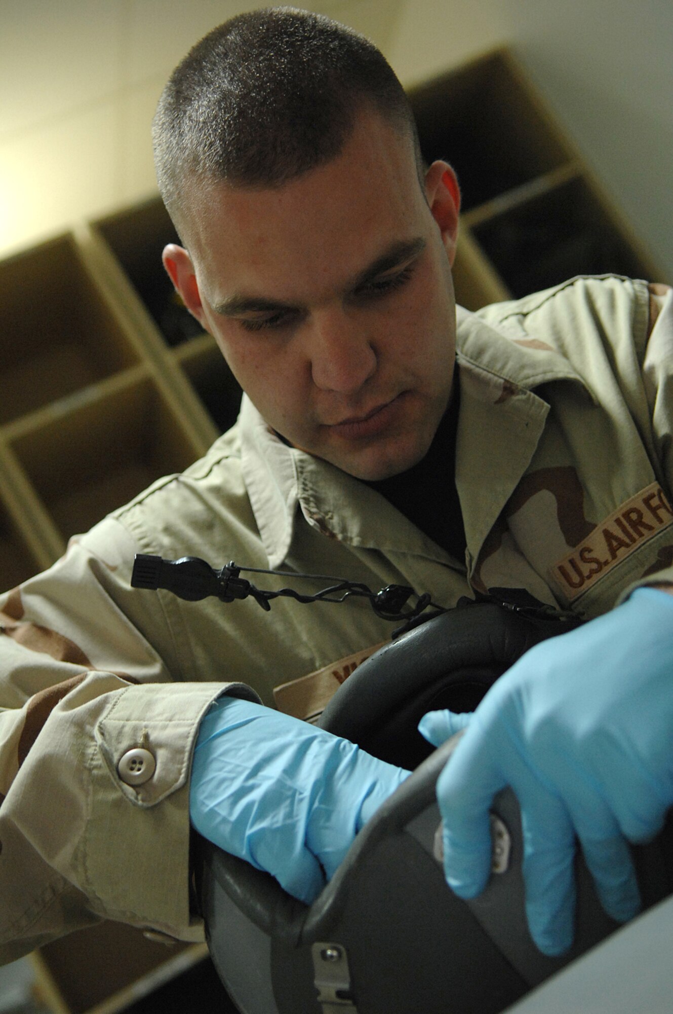BALAD AIR BASE, Iraq -- Airman 1st Class John Vice, a 777th Expeditionary Airlift Squadron aircrew flight equipment technician, performs a 30-day helmet inspection that includes a thorough cleaning and checks for possible malfunctions or tears here, April 16.  By ensuring the operability of aircrew flight equipment, the life support section of the 777 EAS directly affects the success of combat sorties flown everyday. Airman Vice is deployed from Little Rock Air Force Base, Ark. (U.S. Air Force photo/ Senior Airman Julianne Showalter) 