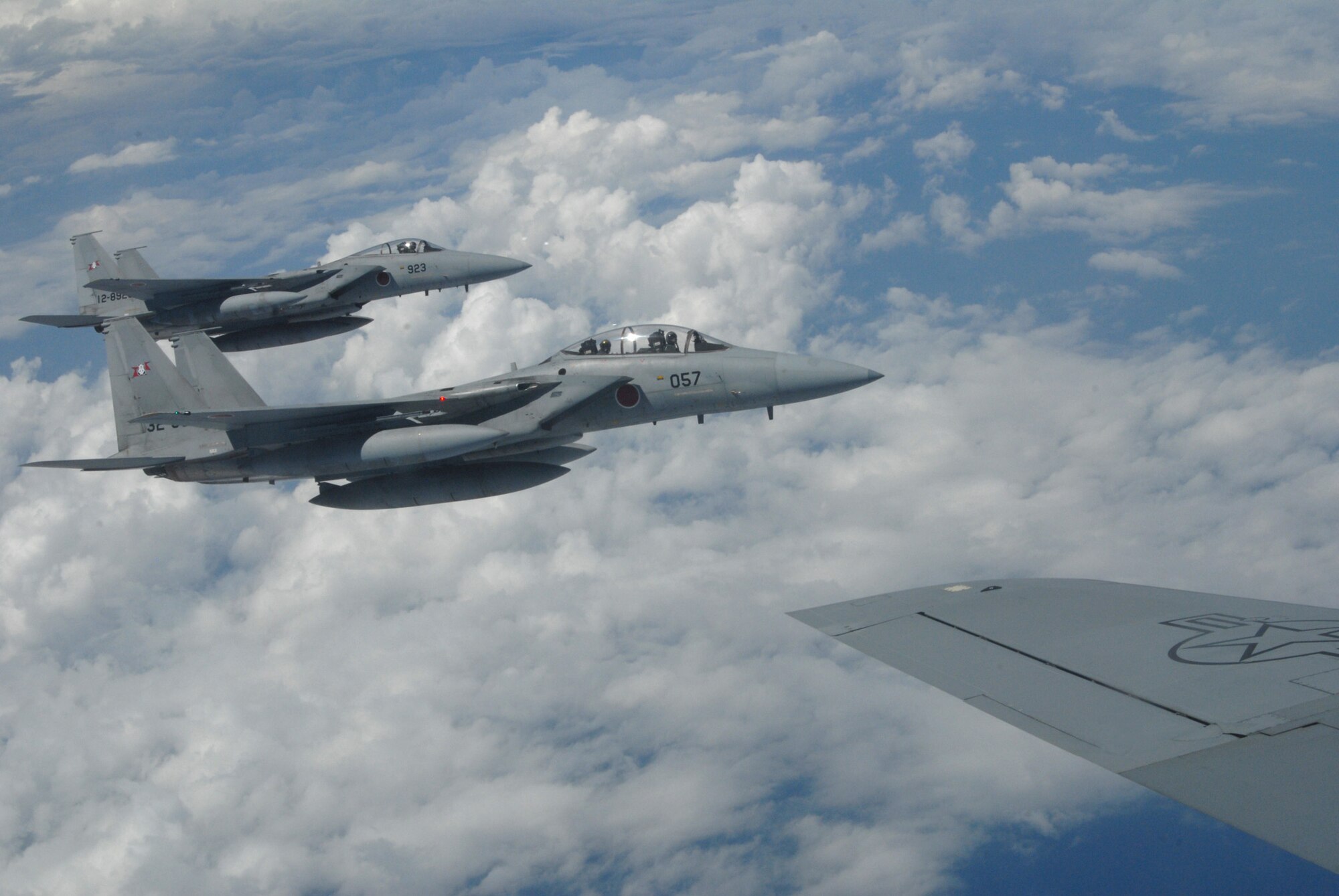 F-15s piloted by Japan Air Self Defense Force members fly on the wing of a 909th Air Refueling Squadron KC-135 during training at Kadena Air Base, Japan. The training was conducted to familiarize JASDF members with U.S. Air Force refueling procedures.(U.S.photo/Staff Sergeant Darnell T. Cannady)