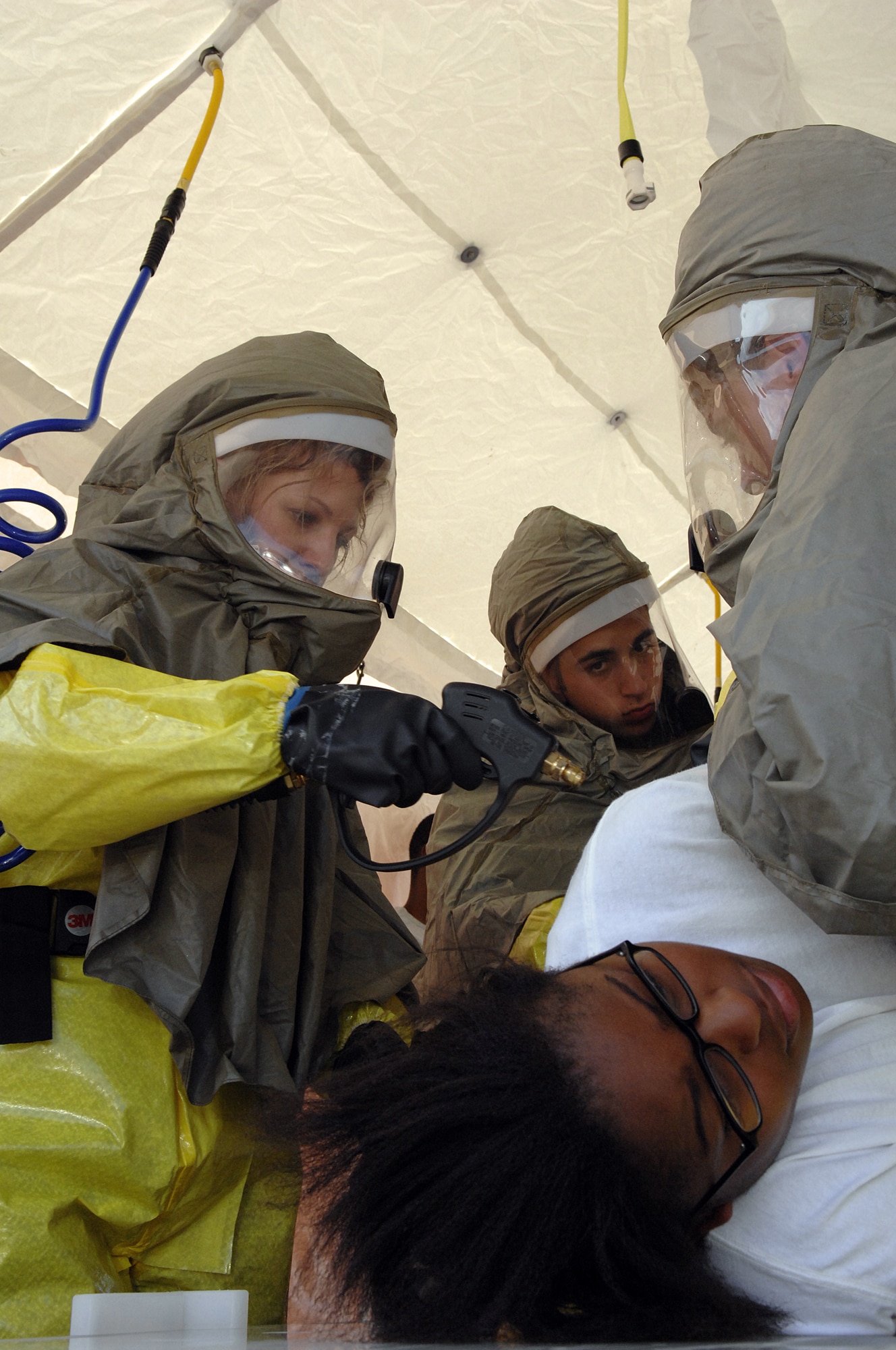 ANDERSEN AIR FORCE BASE, Guam -- The Andersen Decontamination Team simulates hosing down Airman First Class Keesha Harris as she acts as the victim in the new in-place patient decontamination capabilities during an exercise April 16 at Andersen Air Force Base, Guam. The IPPDC allows medics to decontaminate patients in the field during a chemical or biological attack. Airman Harris is with the 36th Medical Group, Andersen AFB, Guam. (U.S. Air Force photo by Staff Sgt. Vanessa Valentine)

