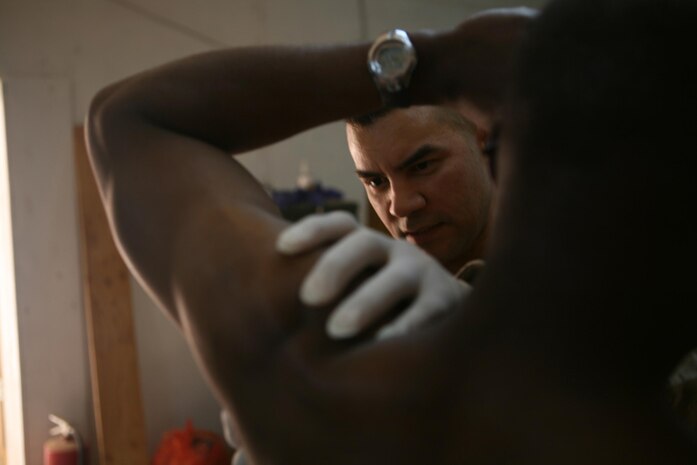 Lieutenant j.g. David M. Viayra, physician assistant, 3rd Battalion, 4th Marine Regiment, Regimental Combat Team 5, from Norwalk, Calif., examines a patient at the Battalion Aid Station at Camp Hit, Iraq, April 22. Corpsmen with 3rd Battalion, 4th Marine Regiment, not only treat Marines, but sometimes Iraqi Police, Iraqi Army, contractors and even civilions.