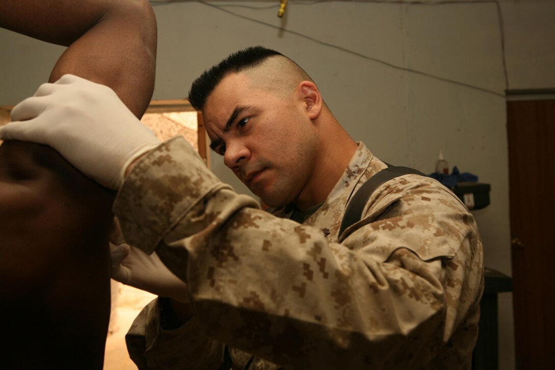 Lieutenant j.g. David M. Viayra, physician assistant, 3rd Battalion, 4th Marine Regiment, Regimental Combat Team 5, from Norwalk, Calif., examines the armpit of a patient in the Battalion Aid Station at Camp Hit, Iraq, April 22. Corpsmen with 3rd Battalion, 4th Marines, treat everything from sprained ankles to gunshot wounds and are available 24-hours a day, seven days a week.