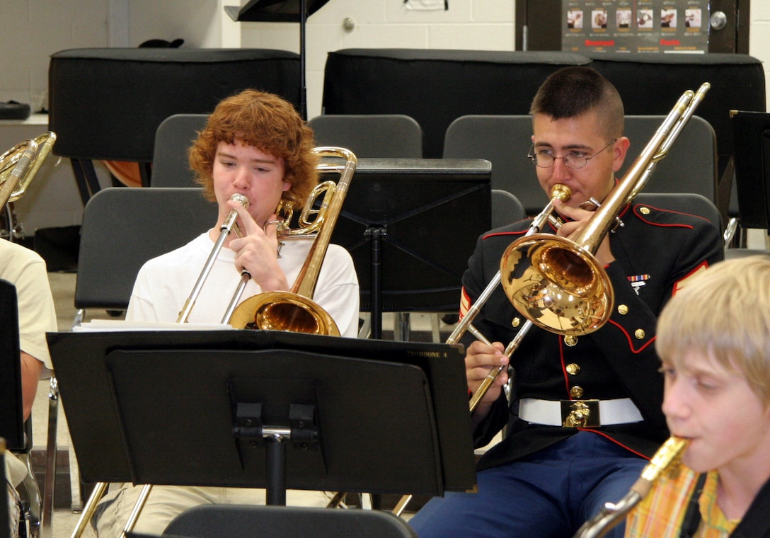 Cpl. Jarod Armes, a trombone player with the Marine Corps Air Ground Combat Center Twentynine Palms, Calif., Brass Quintet, plays along side Chris Winker, a student at Thornapple Kellogg High School in Kalamazoo, Mich., during the quintet's clinic at the school April 23. The quintet went on a five-day tour of Recruiting Station Lansing April 21-25, performing for the public and offering clinics for students.