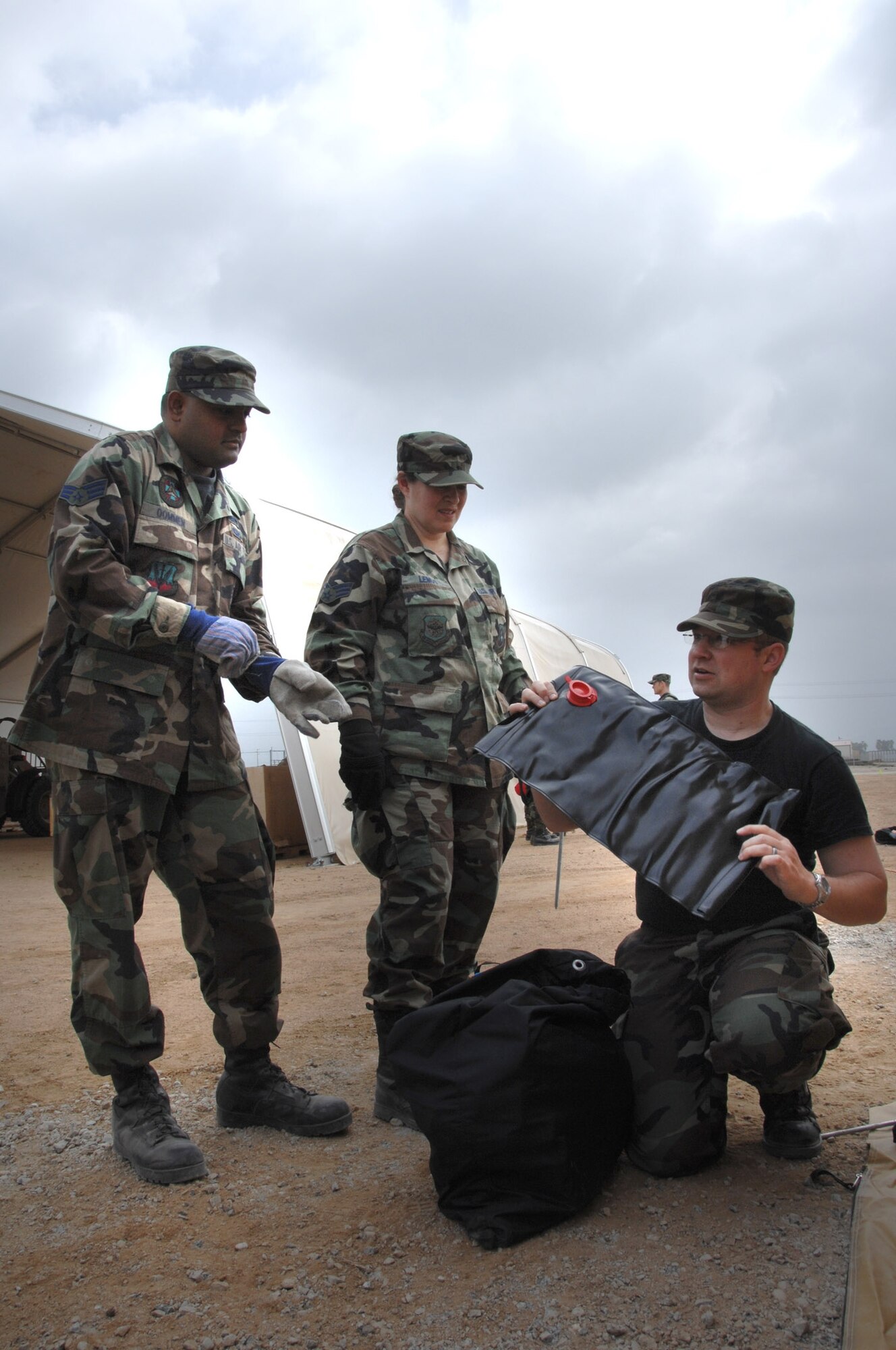 Senior Airman Chris Valenzano (right), 163d Civil Engineer Squadron, explains how to set up a decontamination tent to Senior Airmen Shawn Oommen and Vernonica Lemus, also from the 163d CES at March Air Reserve Base.  (U.S. Air Force photo by Technical Sgt. Julie Avey)