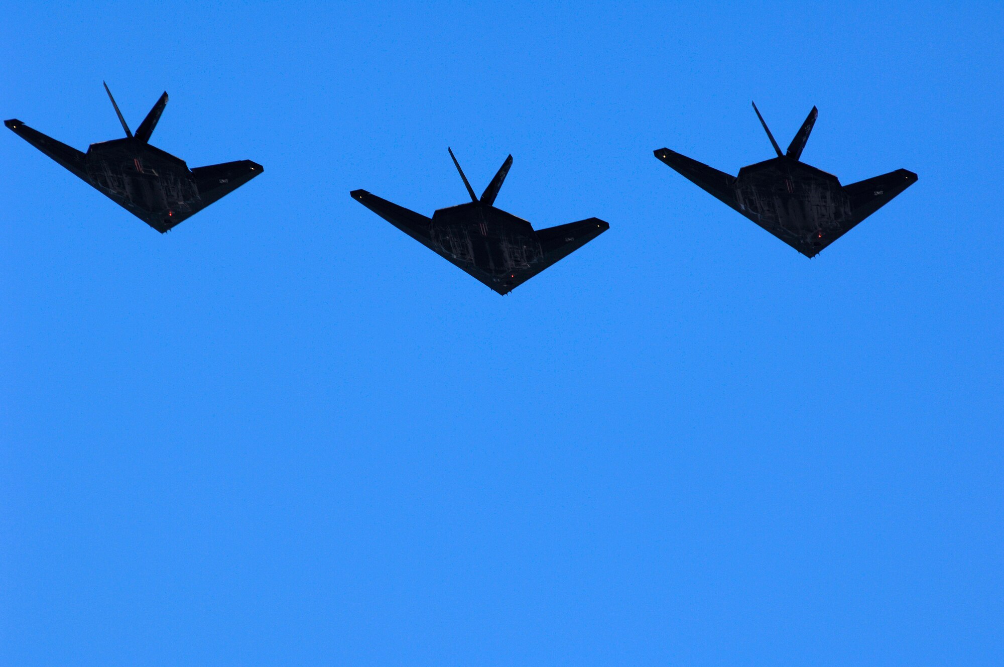 Three of the final four F-117A Nighthawk's fly over Holloman AFB, N.M. during the Sunset Stealth retirement ceremony, 21 April 2008. The F-117A flew under the flag of the 49th Fighter Wing at Holloman Air Force Base, New Mexico from 1992 to its retirement in 2008. (U.S. Air Force Photo by SSgt Jason Colbert)