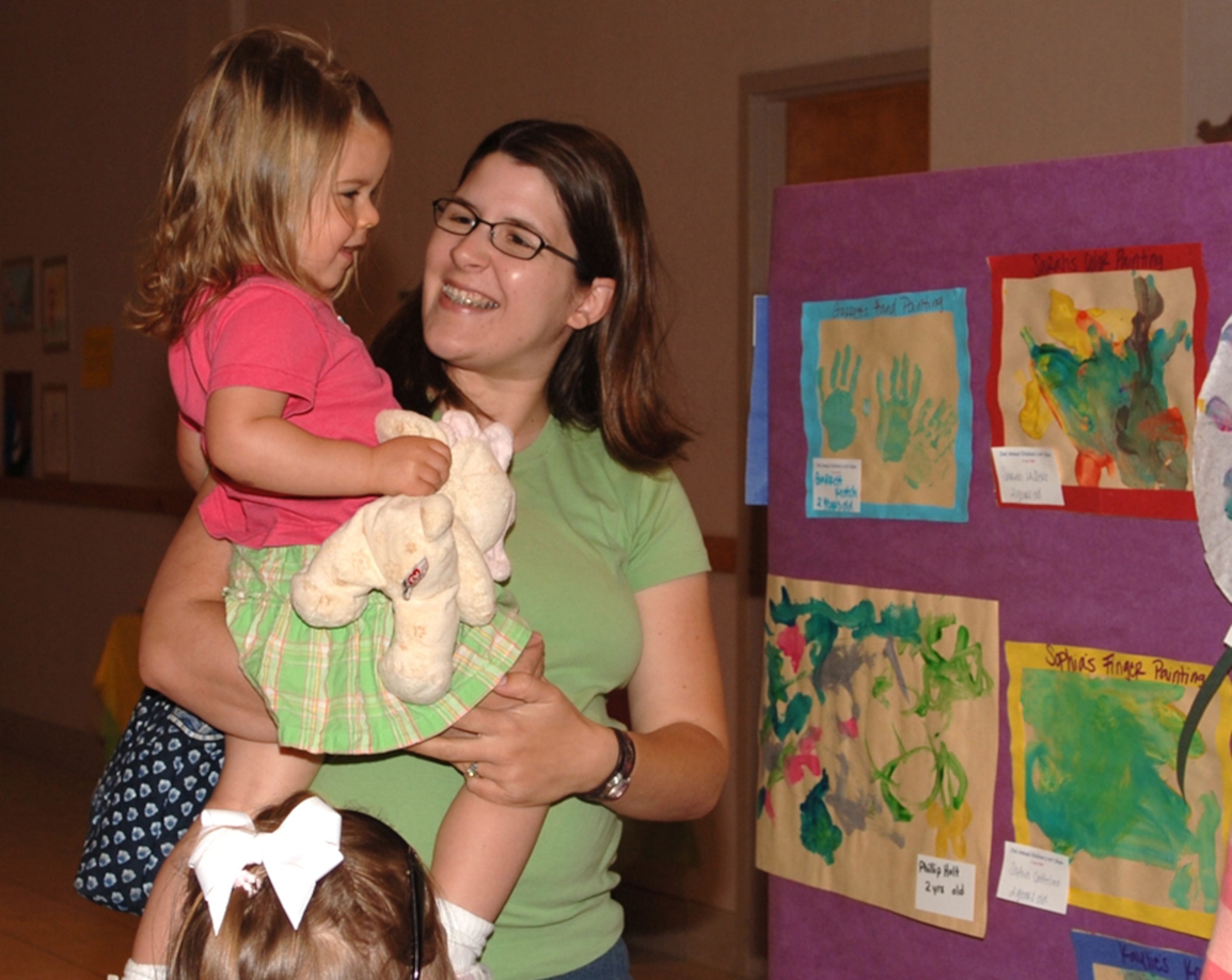 Lindsey Lassere, wife of Capt. Chad Lassere, 37th Flying Training Squadron, looks at art with her daughter Sarah Thursday. The Youth Center and Child Development Center hosted its 2nd Annual Children's Art Show at the Services Complex. The children's art was on display for parents and the base to see. (U.S. Air Force photo by Elizabeth Owens)
