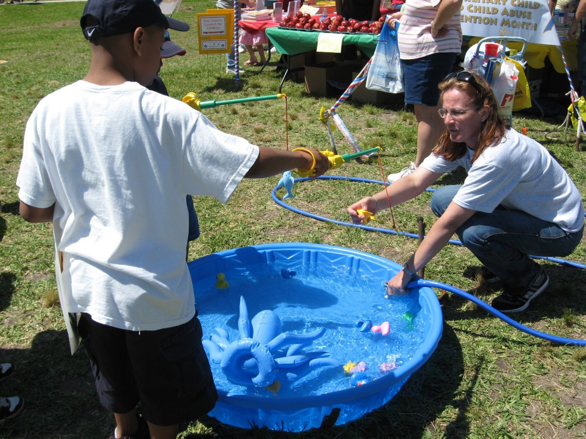 Sherri Ward helps children “fish” while volunteering for Bay County Council for Children and Healthy Start at KidsFest. (U.S. Air Force photo by Chrissy Cuttita)
