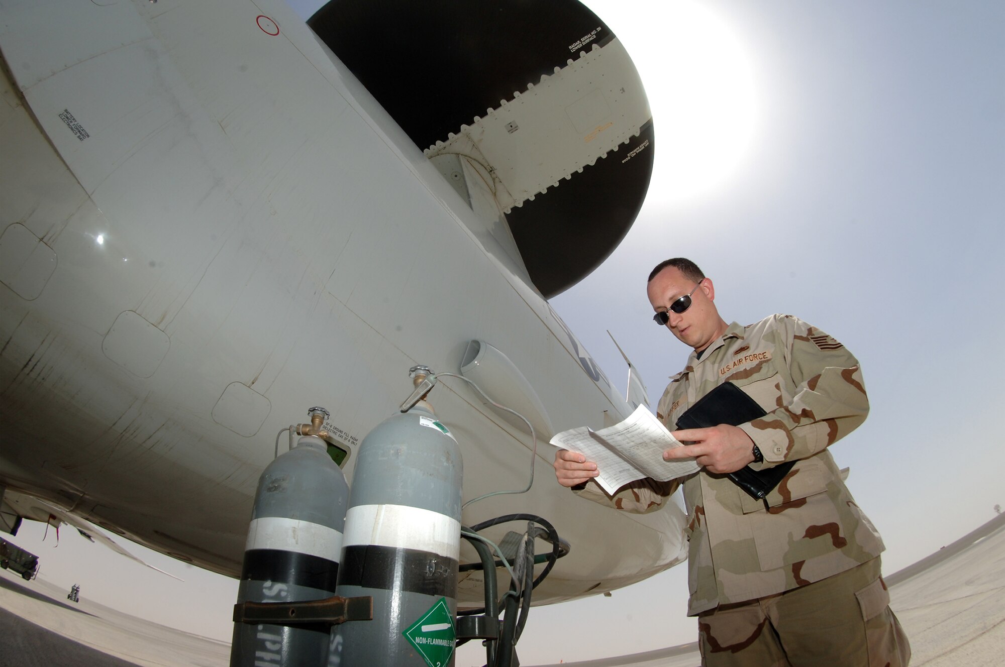 Tech. Sgt. Cory Huffer, 380th Expeditionary Maintenance Group quality assurance inspector, checks the maintenance record of an E-3 Sentry's sulfur hexafluoride bottles for any irregularities at a base in Southwest Asia, April 17, 2008.(U.S. Air Force photo/Senior Airman Levi Riendeau)