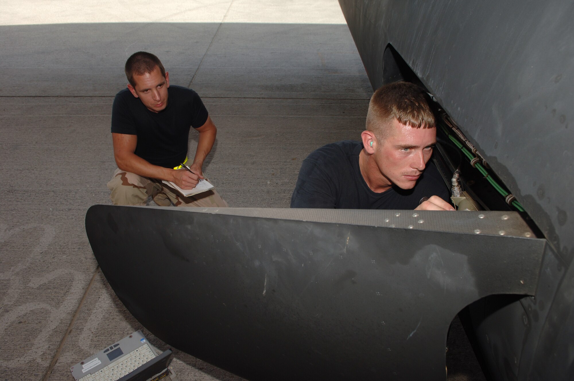 Tech. Sgt. Matthew Klein(left), 380th Expeditionary Maintenance Group quality assurance inspector, conducts a preflight/post flight personnel evaluation with Staff Sgt. William Ehinger, 380th Expeditionary Aircraft Maintenance Squadron, while he works on a U-2 Dragon Lady at a base in Southwest Asia, April 17, 2008.(U.S. Air Force photo/Senior Airman Levi Riendeau)