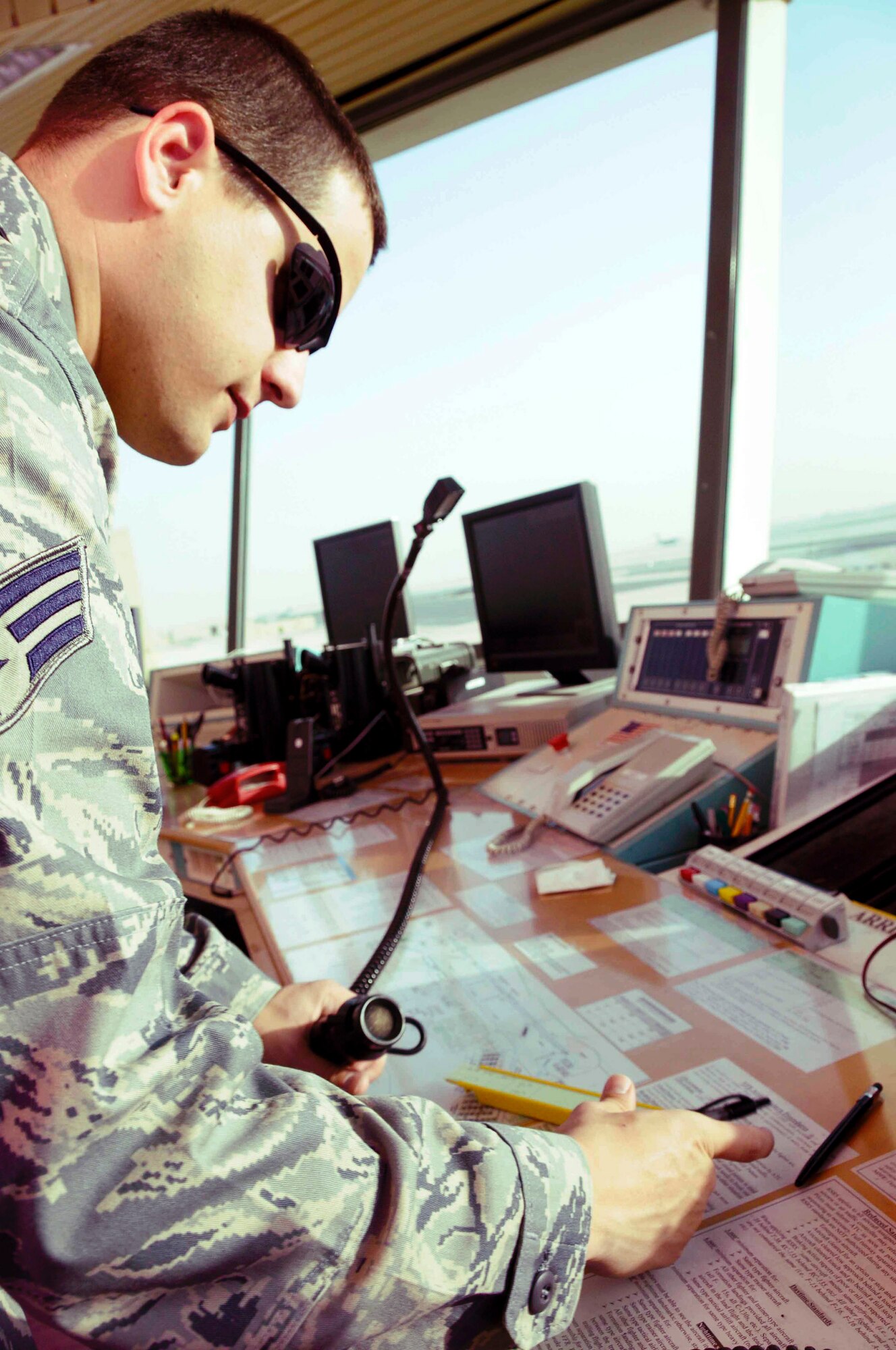 Senior Airman Eric Kindle logs an accurate departure time for an aircraft April 15 from the air traffic control tower at a Southwest Asian air base. As an air traffic control journeyman, Airman Kindle ensures aircraft taking off or landing do so safely and quickly. (U.S. Air Force photo/Senior Airman Domonique Simmons) 
